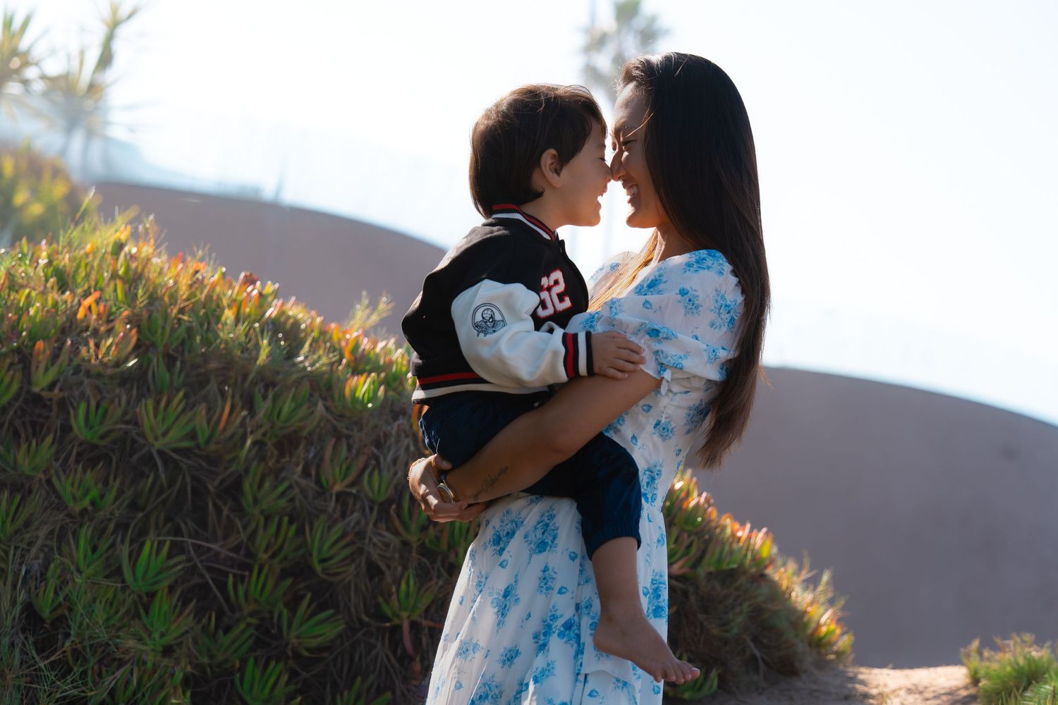 Outdoor motherhood portrait of a mother holding a toddler during a candid family photography session by a Colorado photographer.