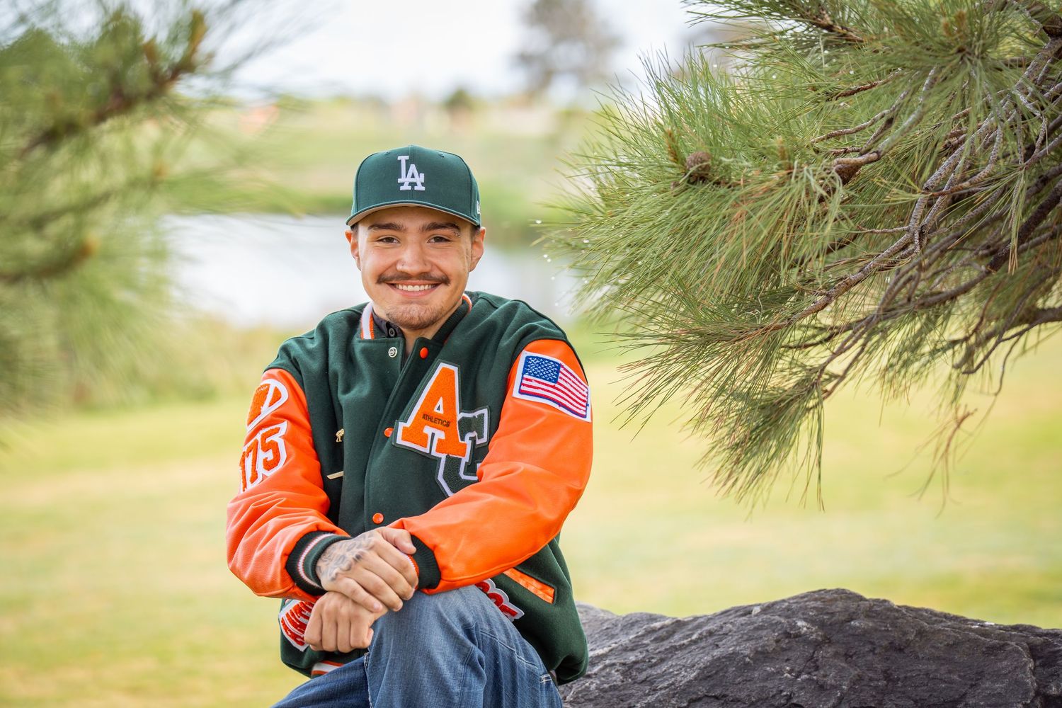 High school senior portrait in varsity jacket during an outdoor senior photography session captured by a Denver senior photographer.