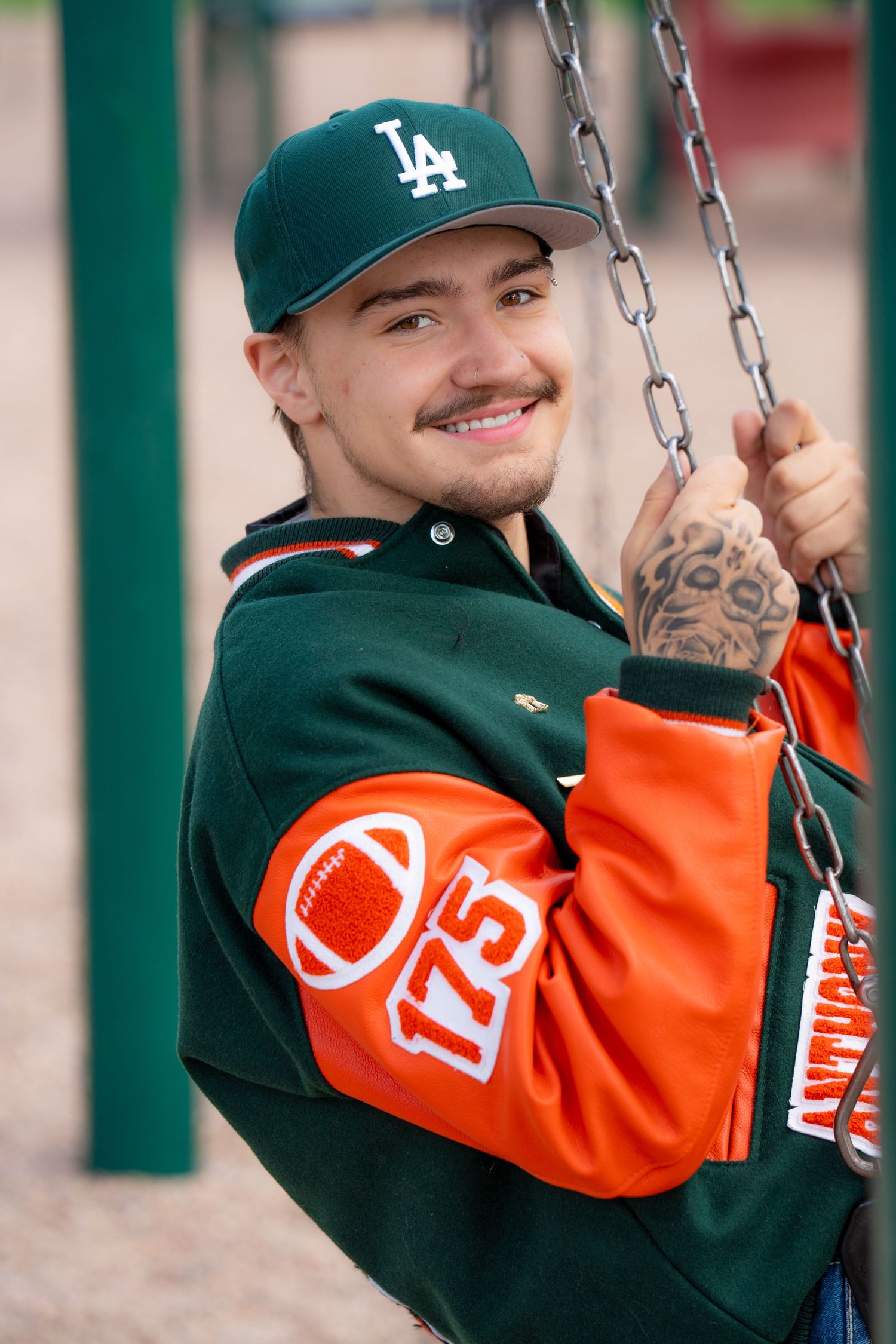 High school senior portrait on playground swing during a fun outdoor senior photography session captured by a Colorado senior photographer.