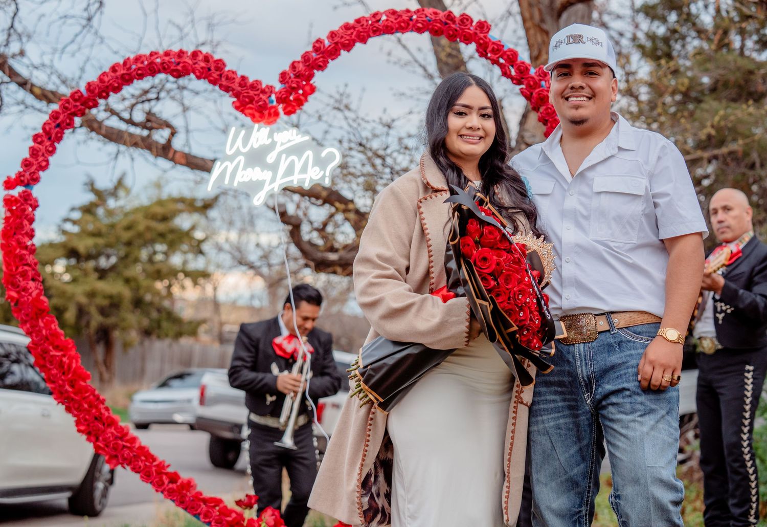 Couple celebrating engagement under heart arch during a romantic proposal photography session captured by a Colorado photographer.
