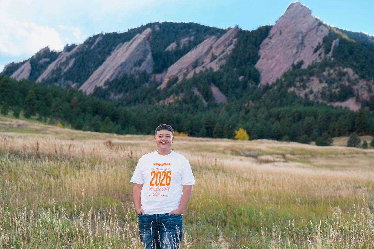 Commerce City High school senior standing in a golden field during sunset, senior photos captured by a Colorado senior photographer.