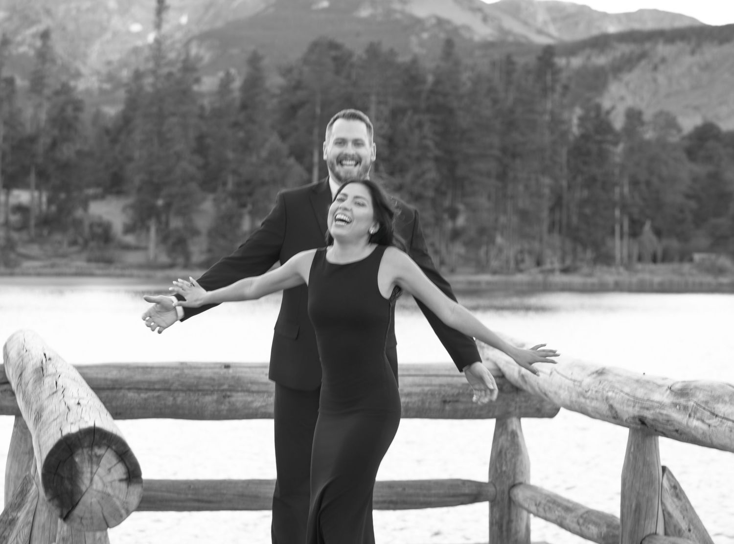 Joyful couple embracing at mountain lake overlook during a natural outdoor couples photography and engagement session in Colorado.