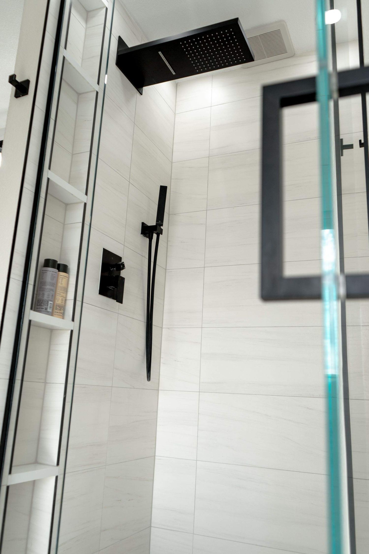 Modern walk-in shower with rainfall showerhead photographed for contractor and real estate project photography in Denver, Colorado.