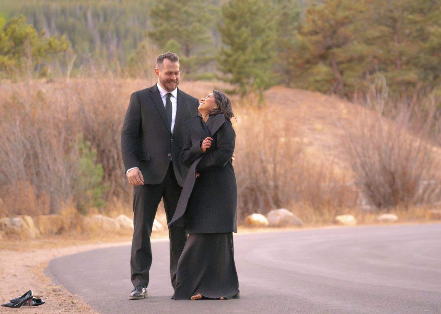 Couple walking together on scenic mountain road during a romantic outdoor engagement photography session captured by a Colorado couples phot