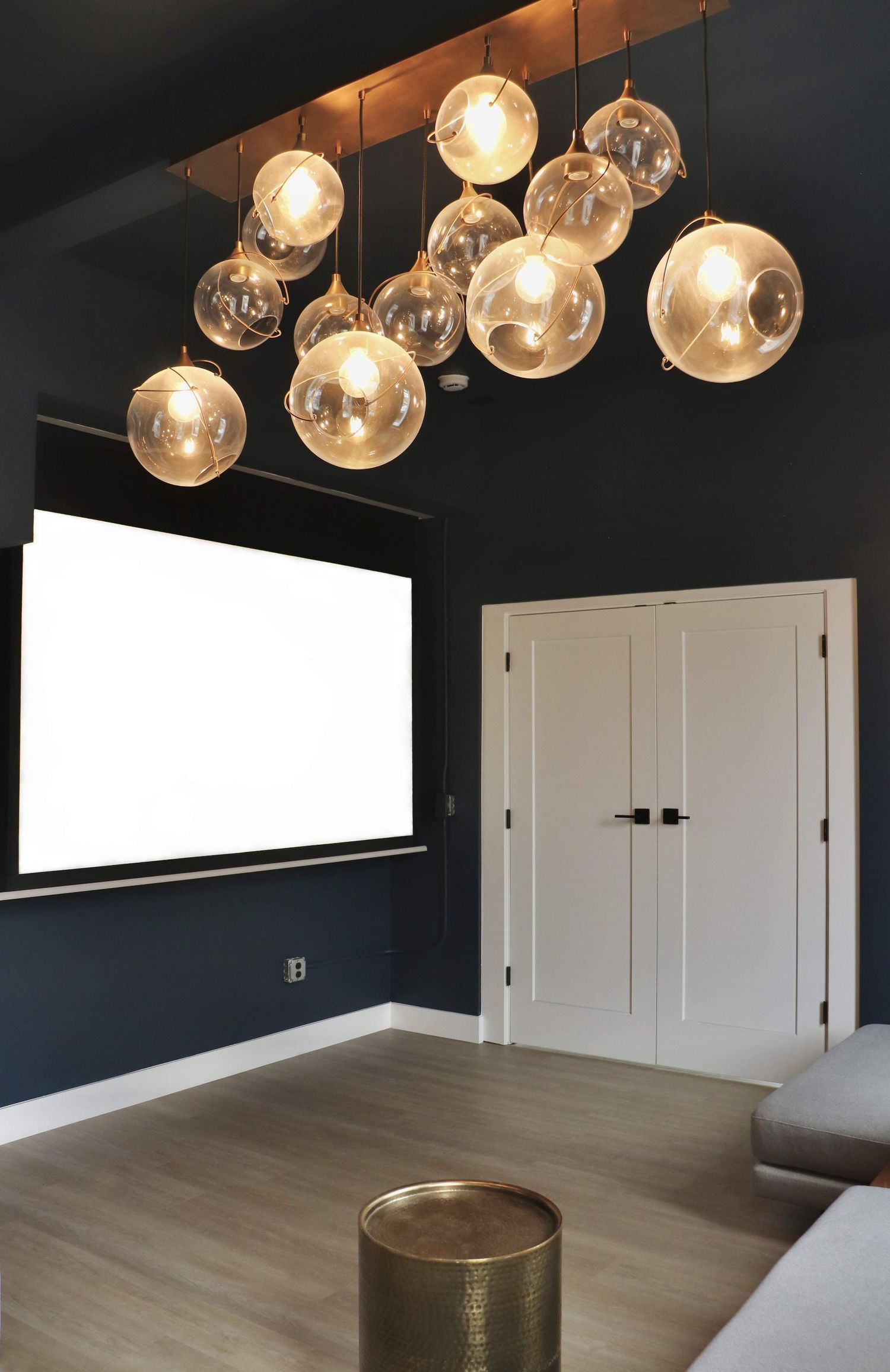 Modern interior room with clustered glass pendant chandelier and dark accent walls photographed for interior design & real estate marketing.