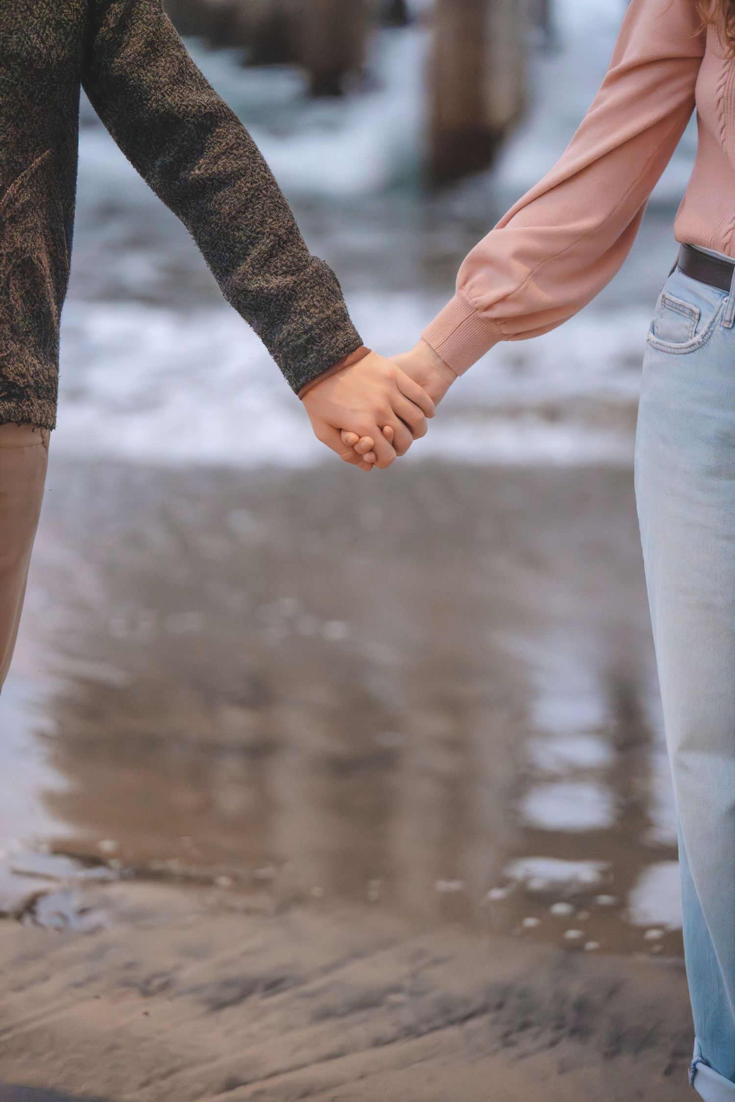 Close up of couple holding hands during a romantic outdoor engagement photography session captured by a Colorado couples photographer.