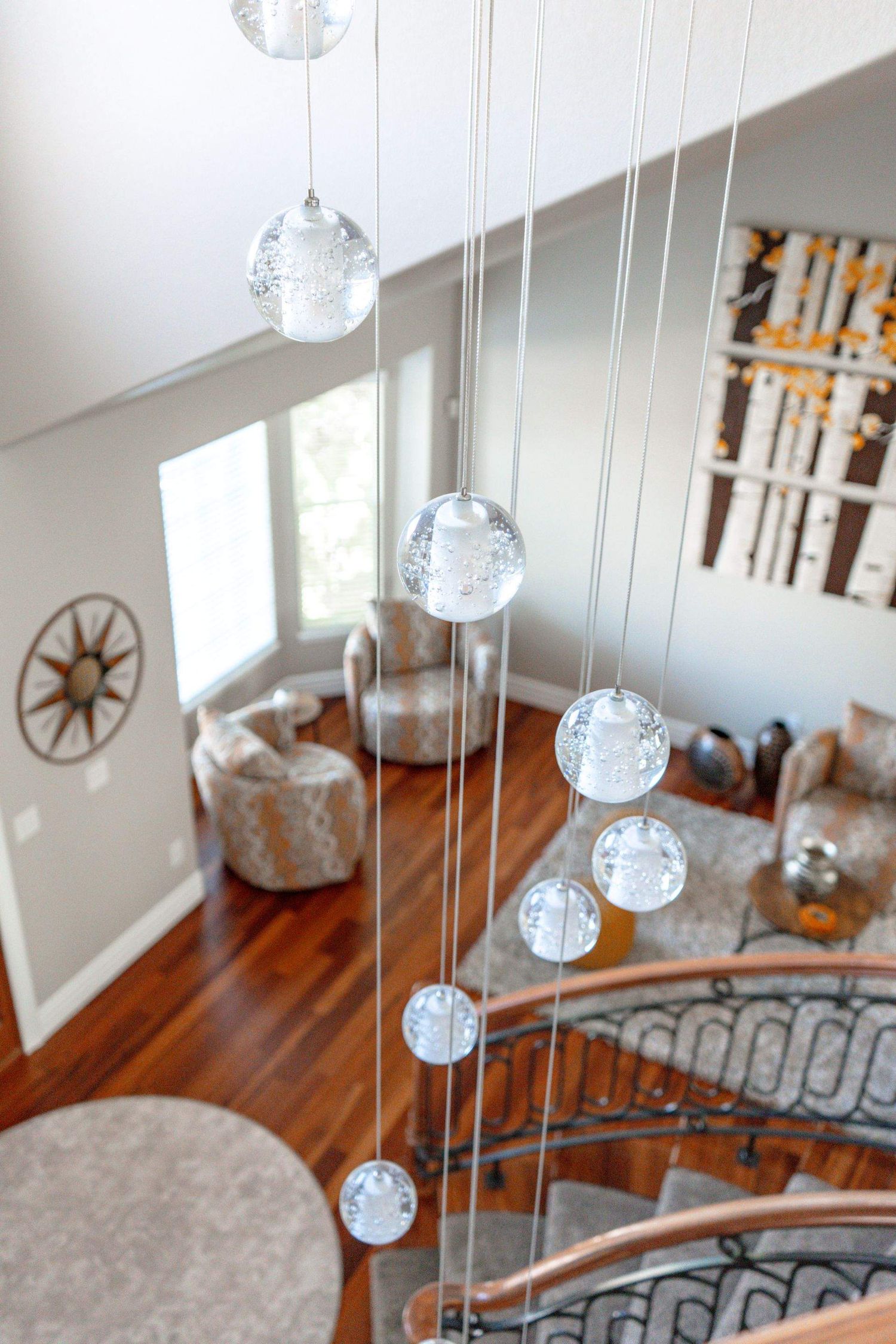 Modern home interior with staircase view and hanging glass pendant lights photographed for Denver real estate and architectural photography.