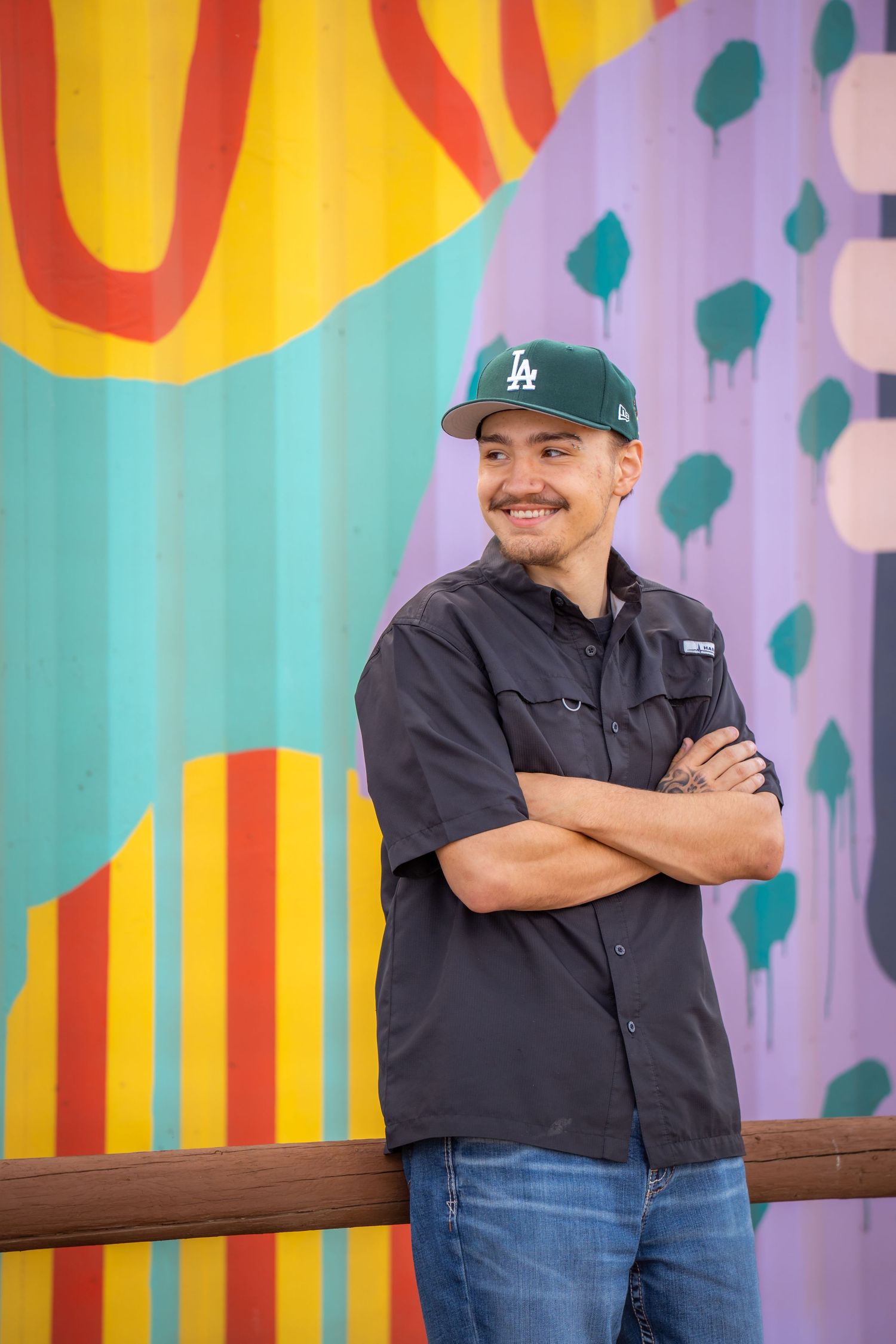High school senior portrait in front of colorful mural during a creative senior photography session by a Colorado senior photographer.