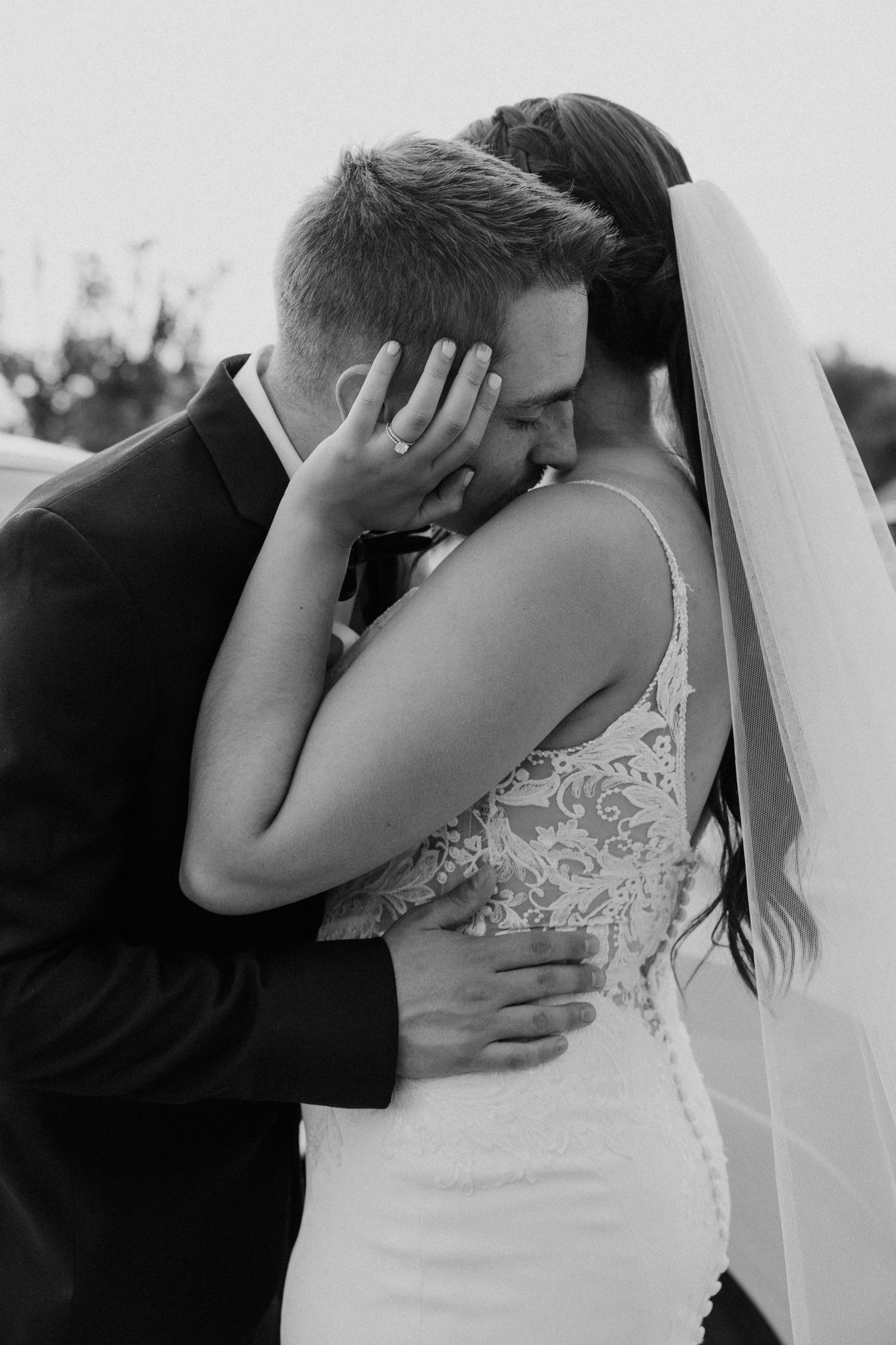Black and white wedding photo showing intimate close-up moments between newlyweds during their first kiss.