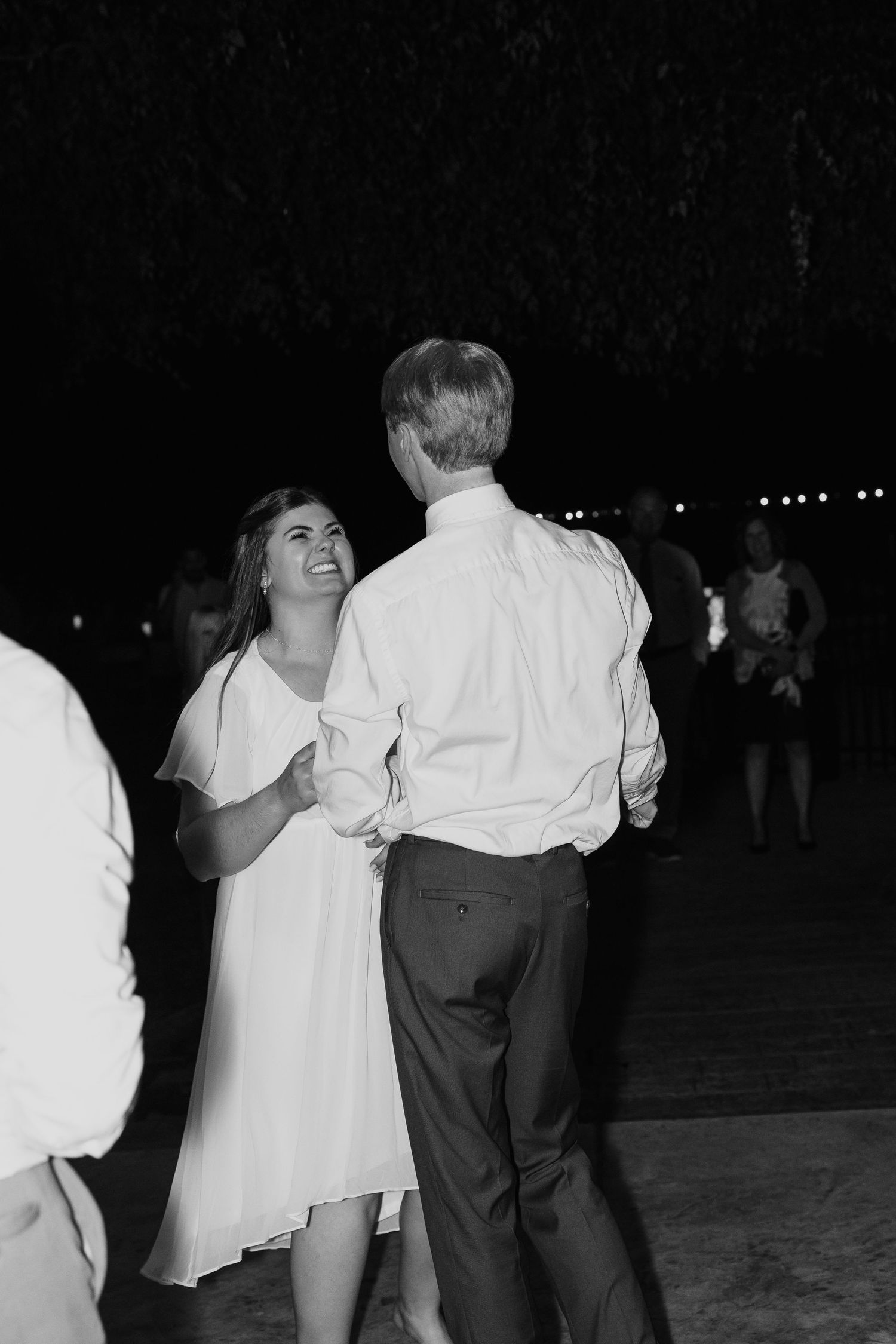 A black and white photograph shows couples dancing together at what appears to be a social gathering or dance event.