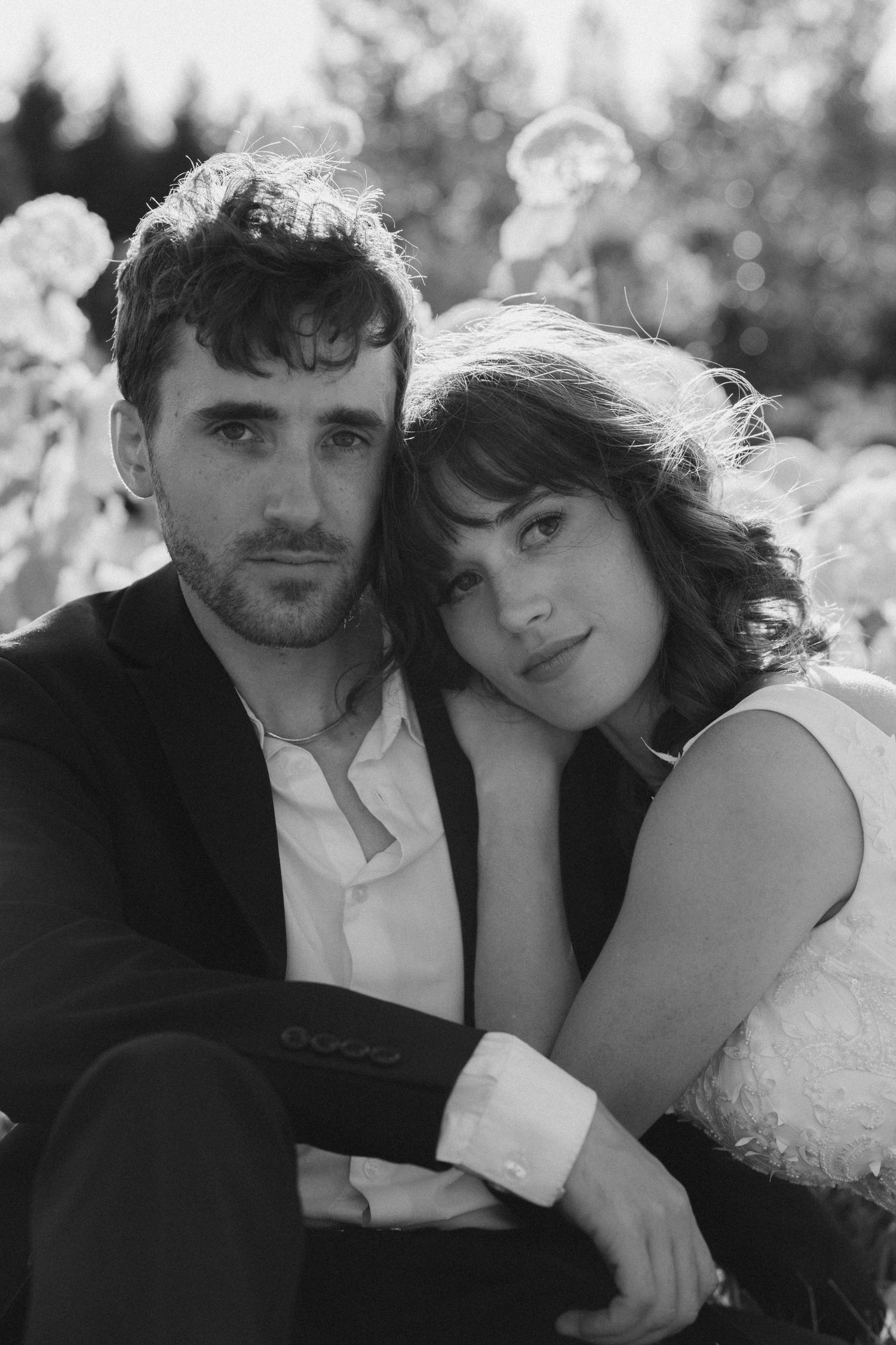 A black and white photo showing a romantic couple posing together in intimate portraits.