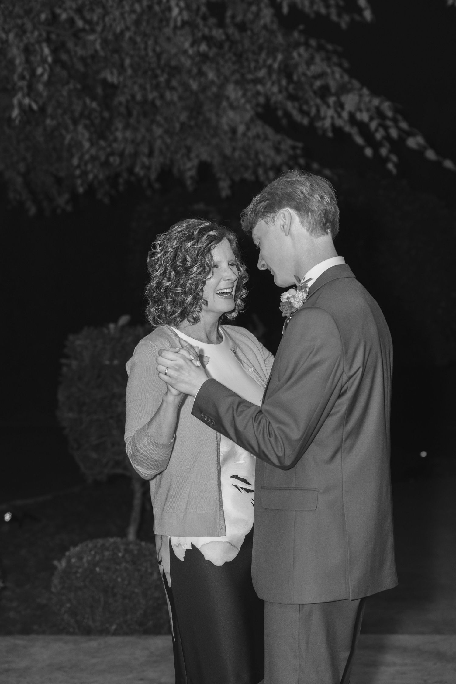 A couple embraces and dances together in a romantic outdoor nighttime setting.