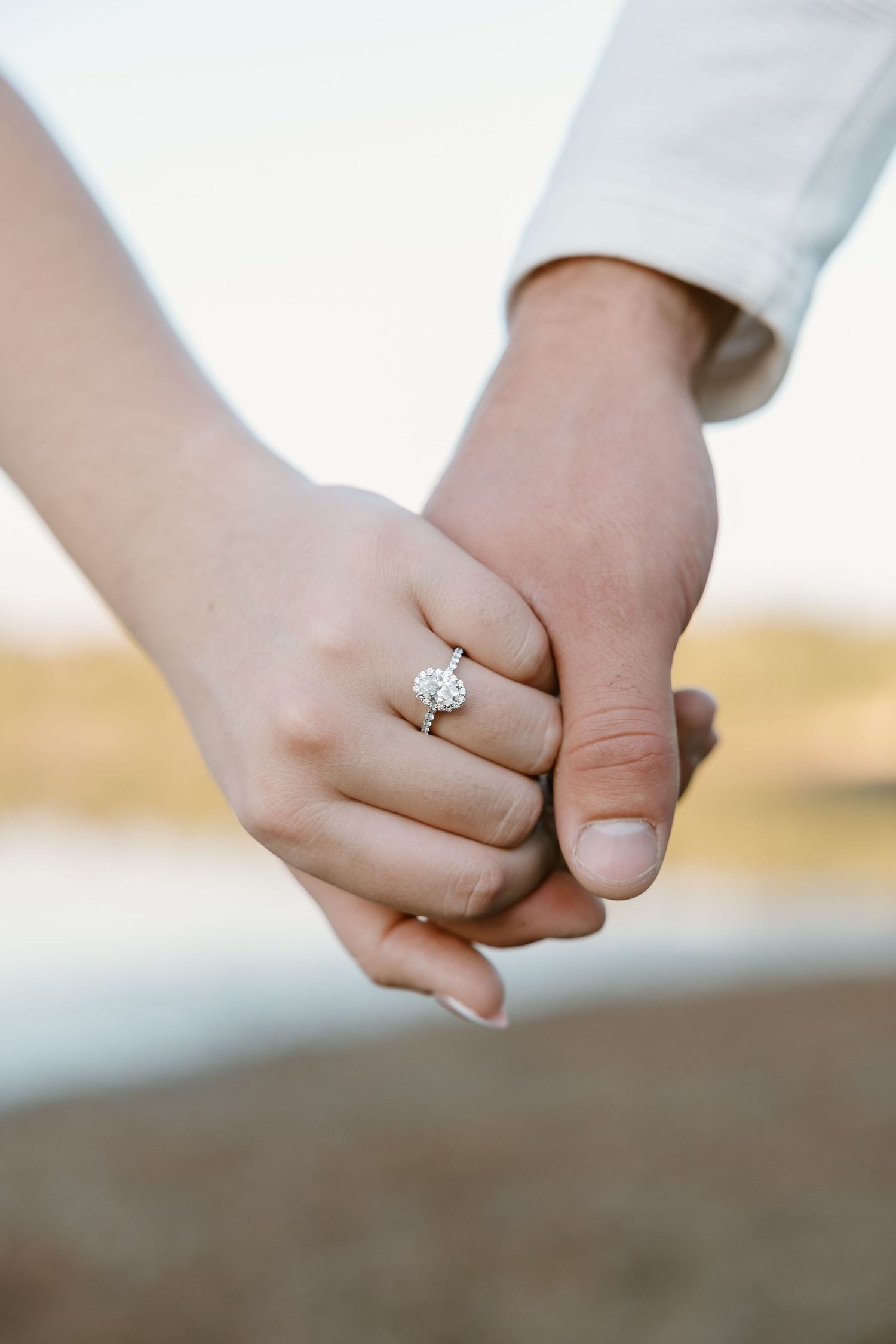 Close-up series of hands holding each other showing engagement ring in natural outdoor lighting at sunset.
