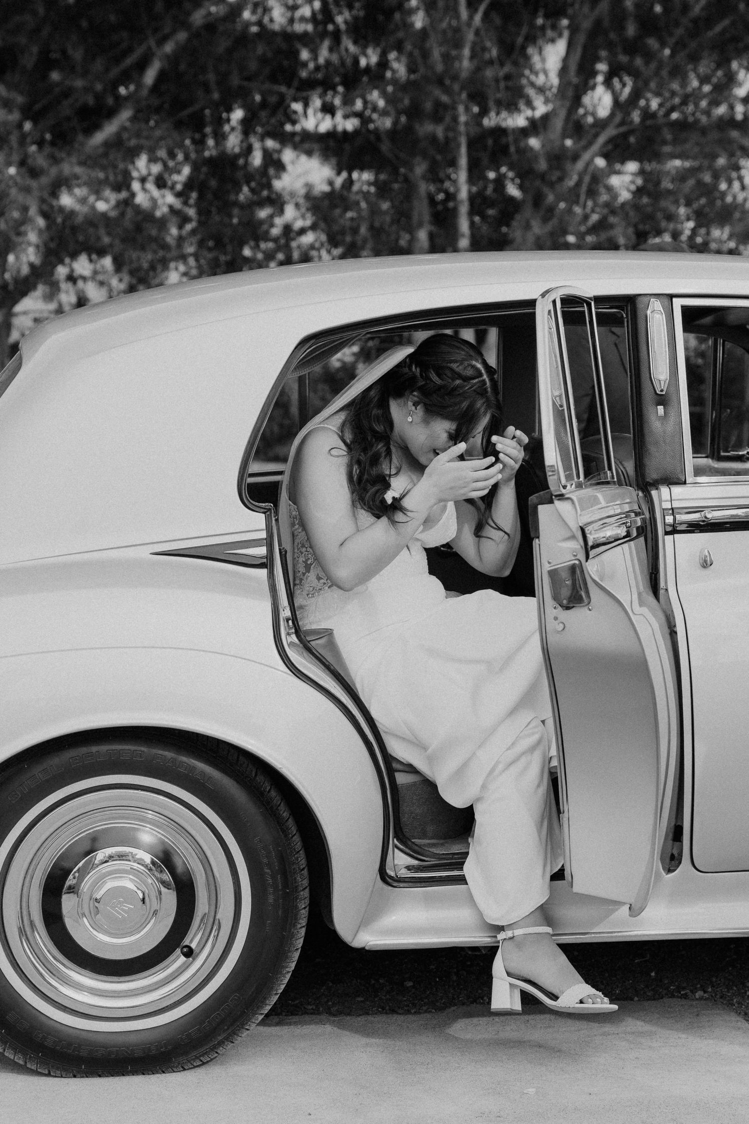 A sequence of black and white photographs showing a person gracefully entering a classic white car from left to right.