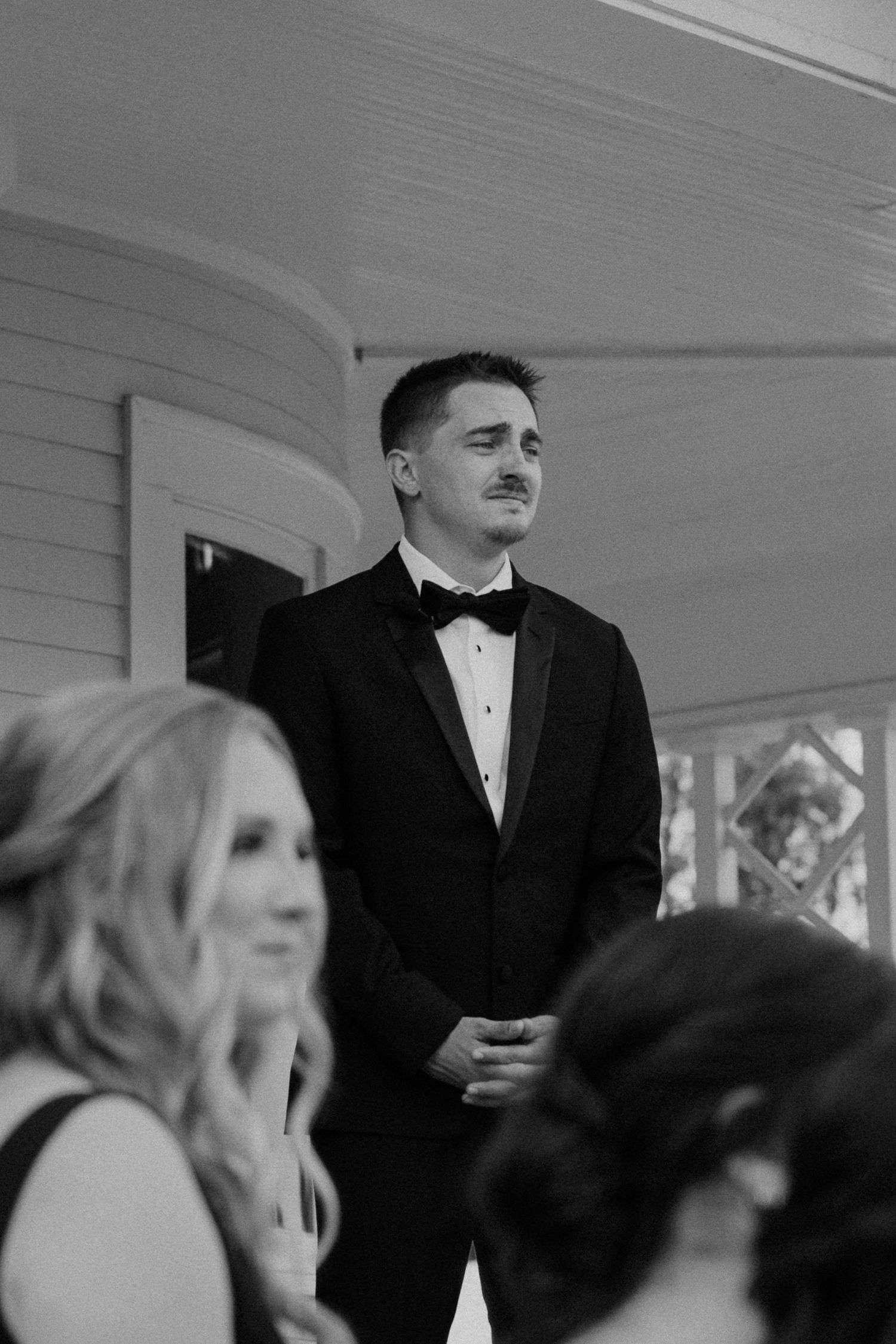 A black and white photo sequence showing guests at a formal event in a venue with white walls.