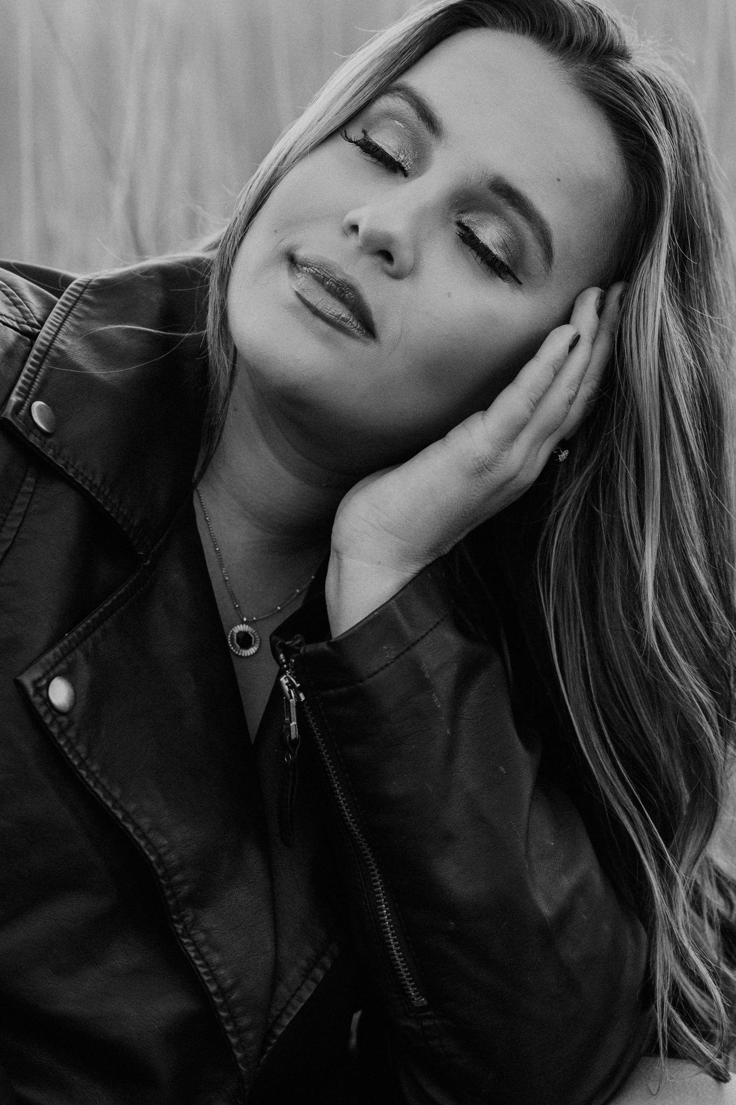 A black and white photo series showing a person with long hair in dramatic poses against a light background.