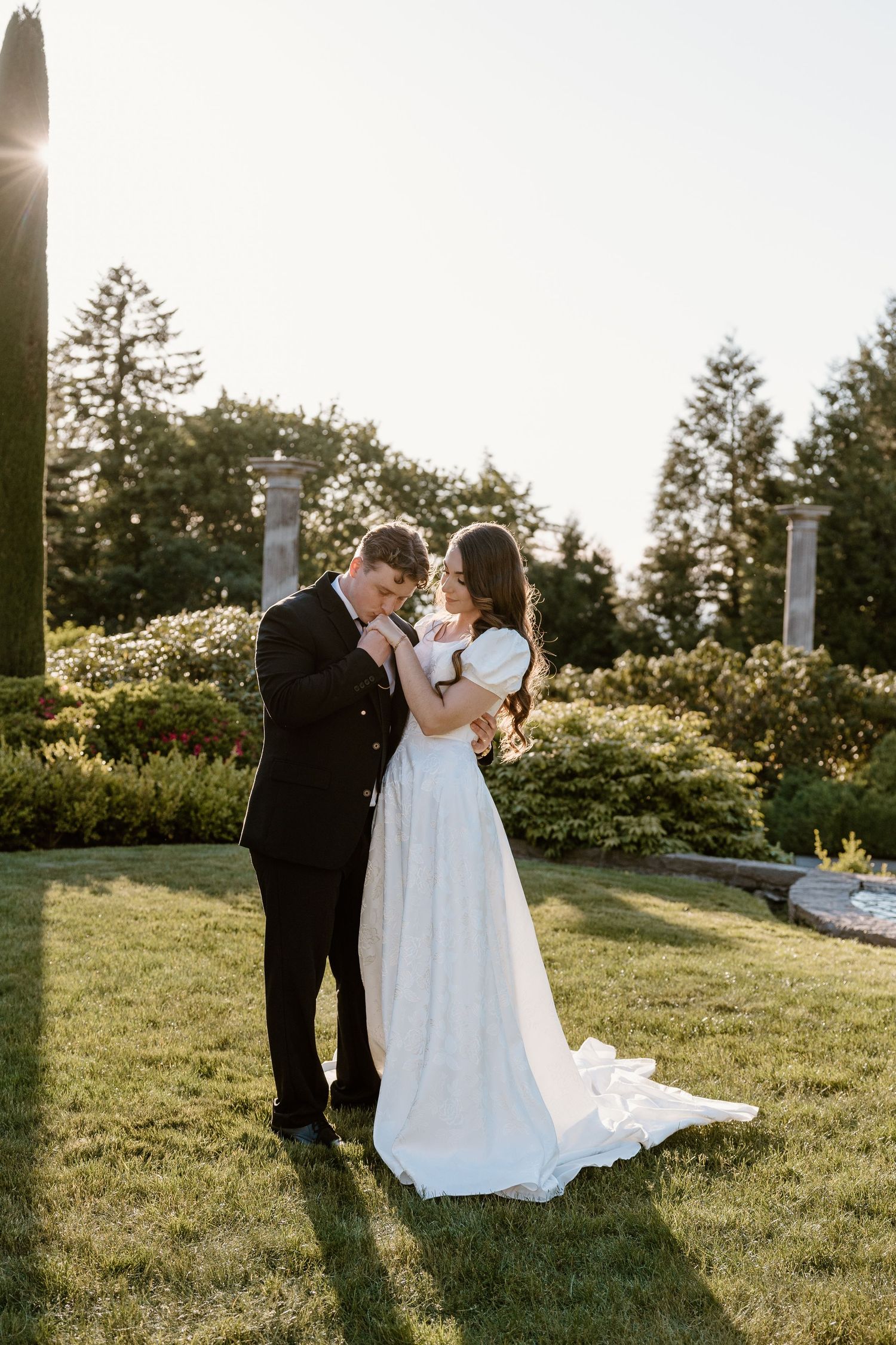 A couple shares an intimate moment during sunset in a garden setting with beautiful golden light.