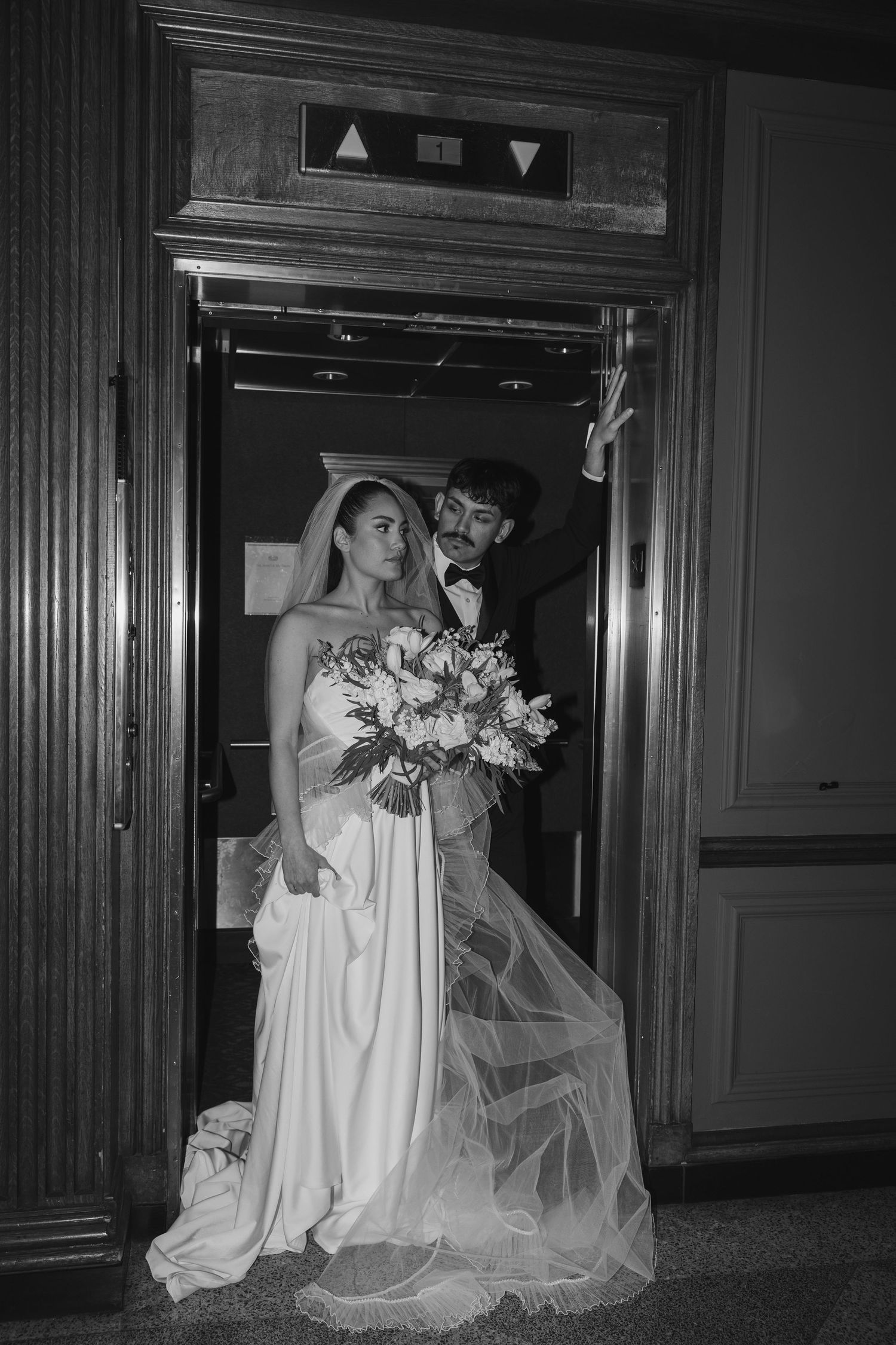 A couple dressed in wedding attire standing in an elevator at the Whitman Hotel in Walla Walla, Washington