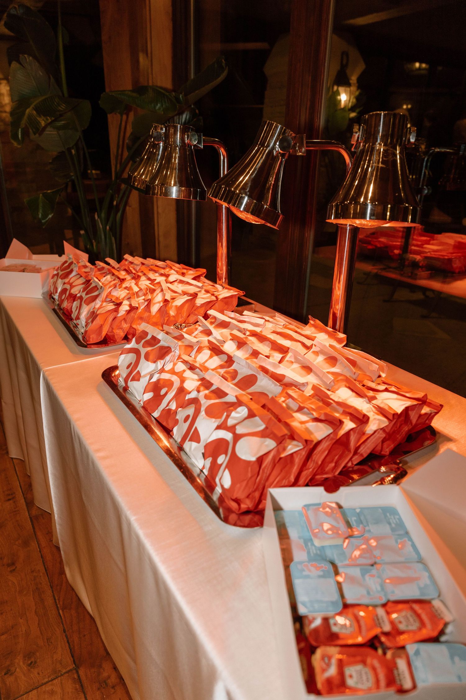 Table display of red and white party favors arranged on white tablecloth.