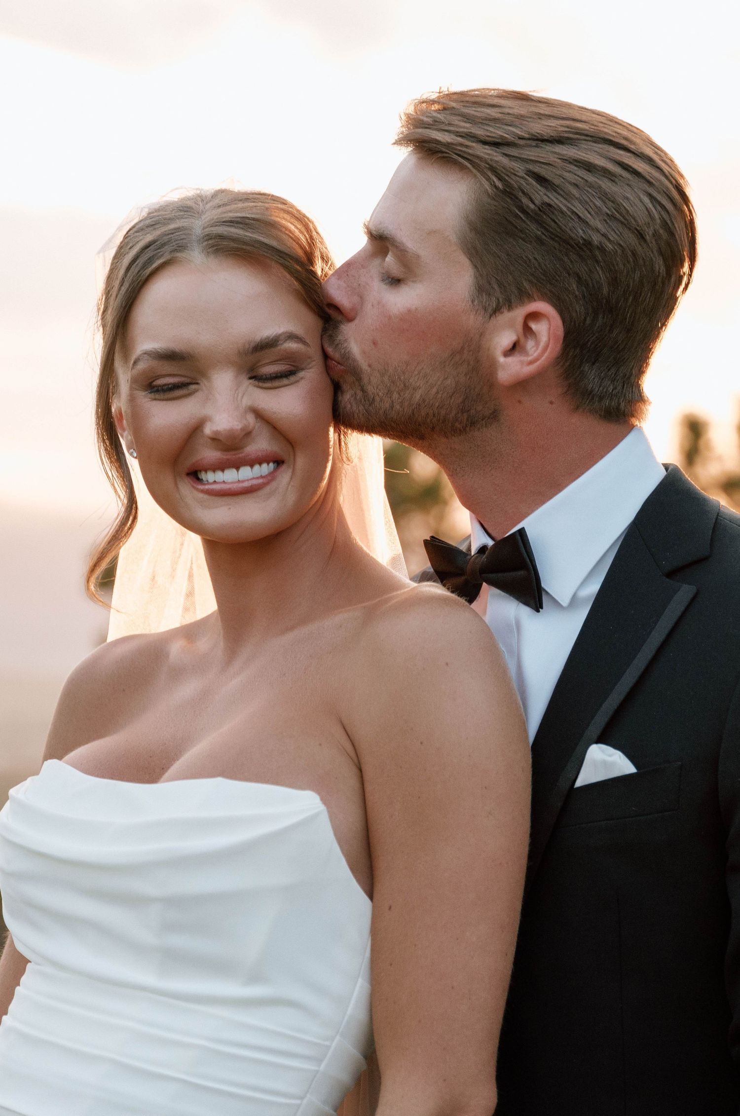 Close-up wedding portrait shows tender moment between couple during golden hour.