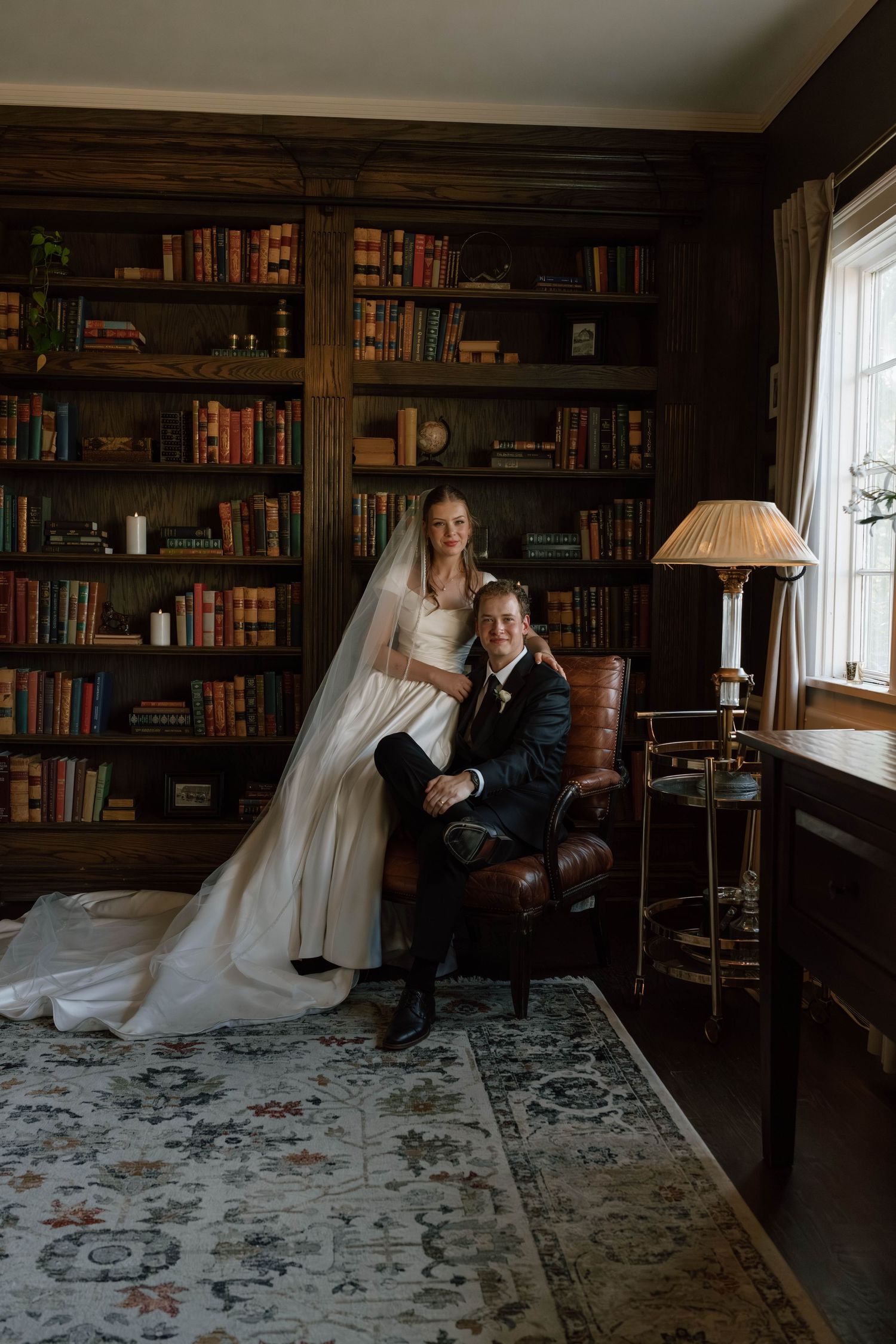 Wedding photo shoot in a classic library setting with dark wood paneling and vintage decor.