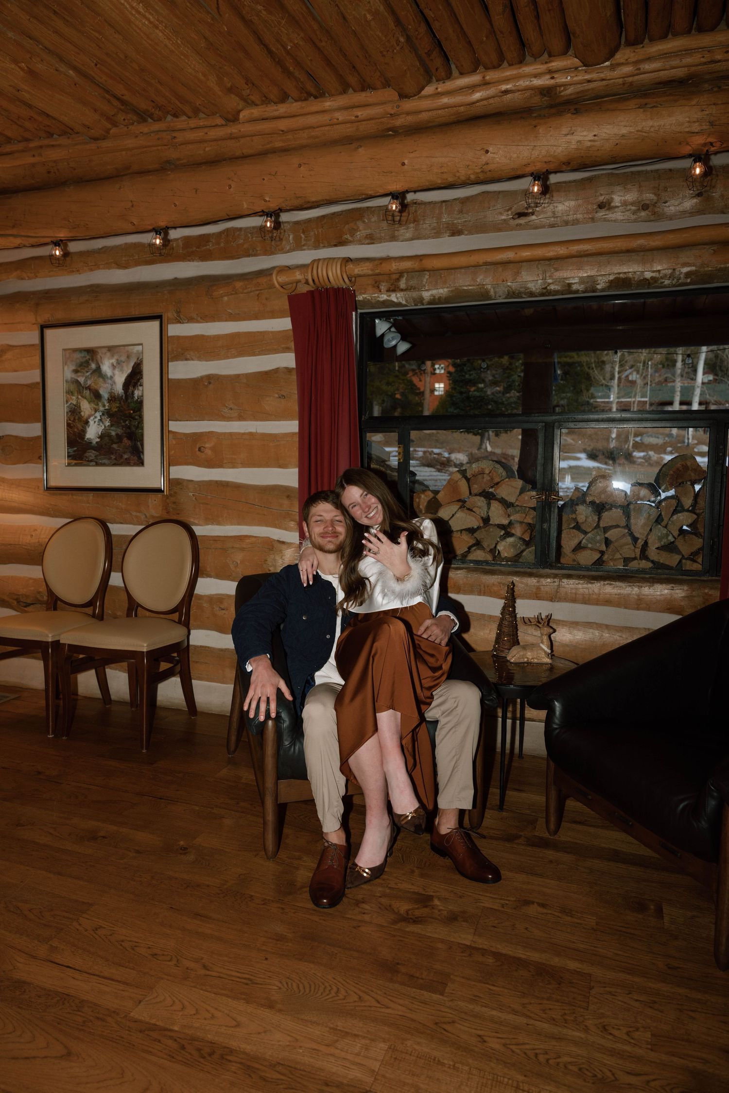 Couple sharing intimate moments on a wooden bench inside a cozy cabin.