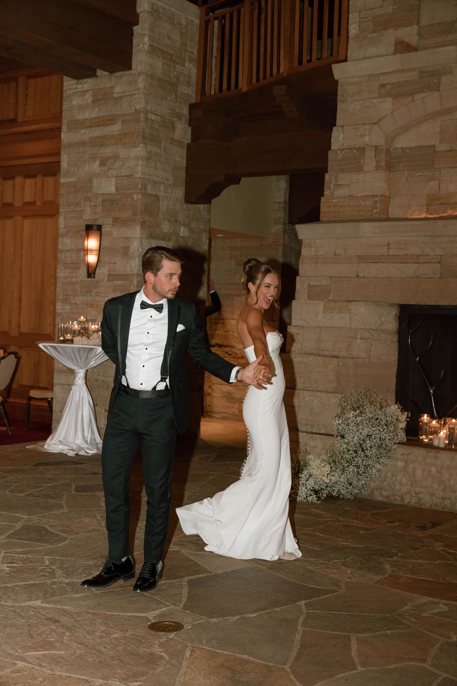 Playful dance sequence on stone patio outside venue during wedding reception.