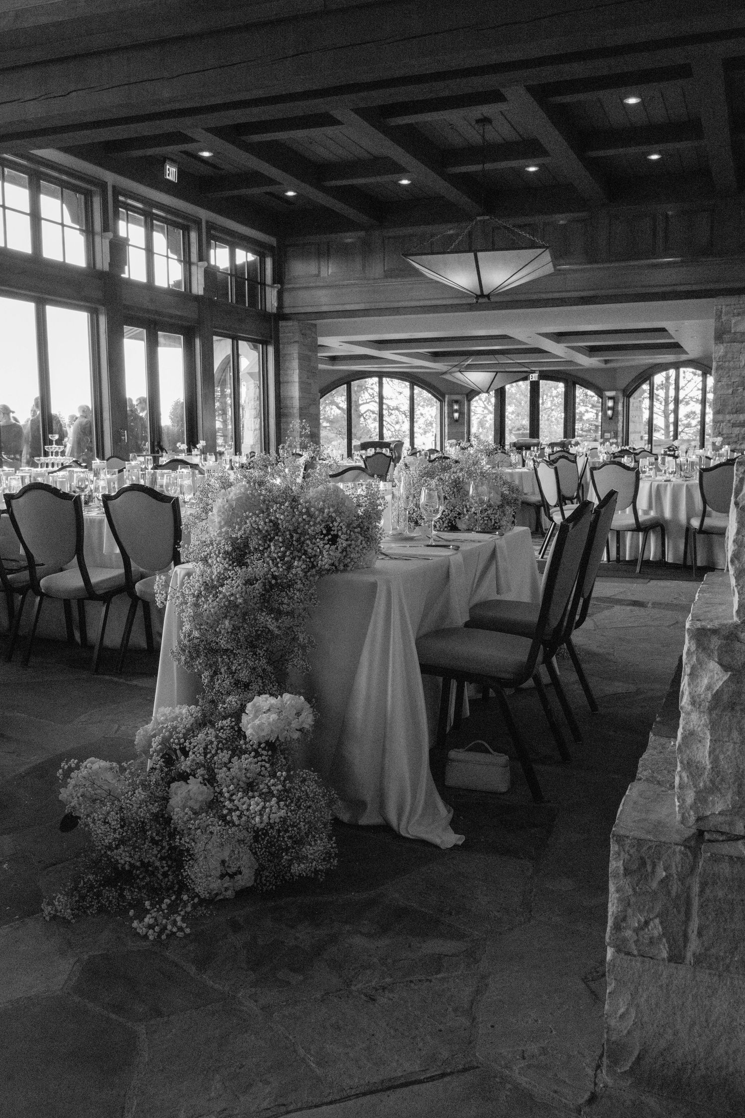 Elegant reception hall with white tablecloths and baby's breath floral arrangements.