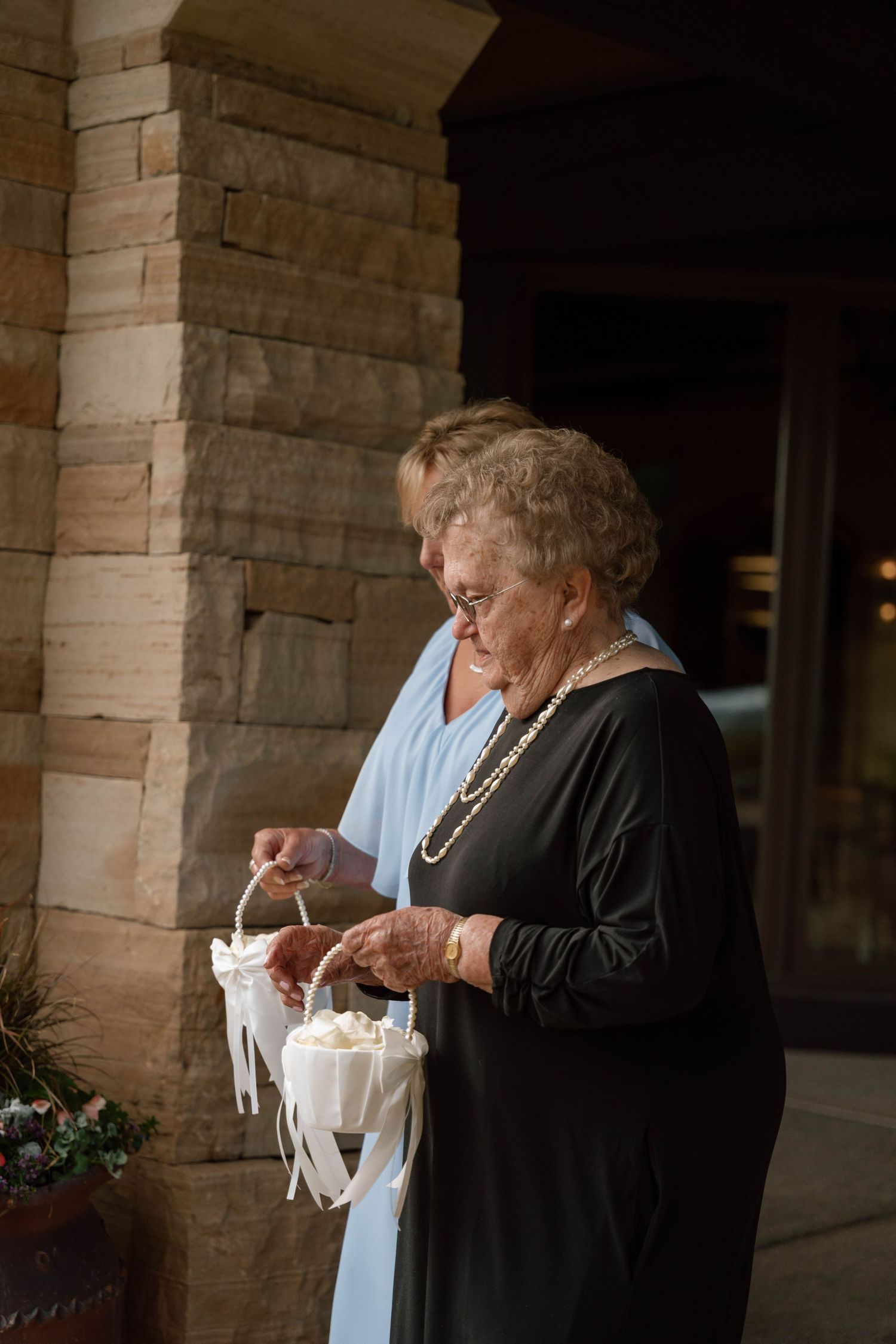 Guests in formal attire enjoying refreshments under a covered stone patio.