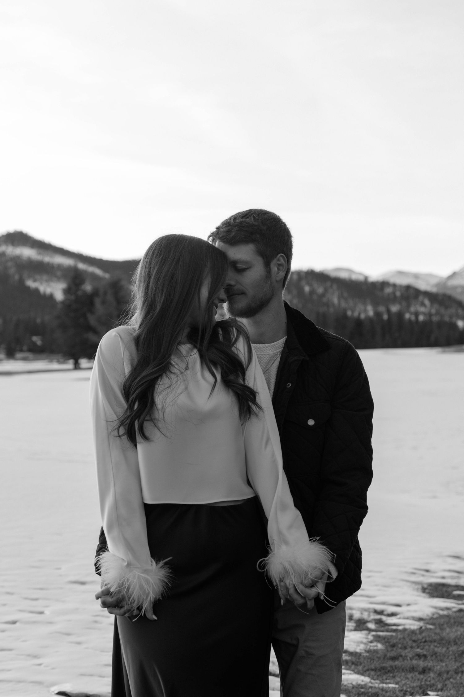 Intimate black and white portraits of a couple by a winter lake.