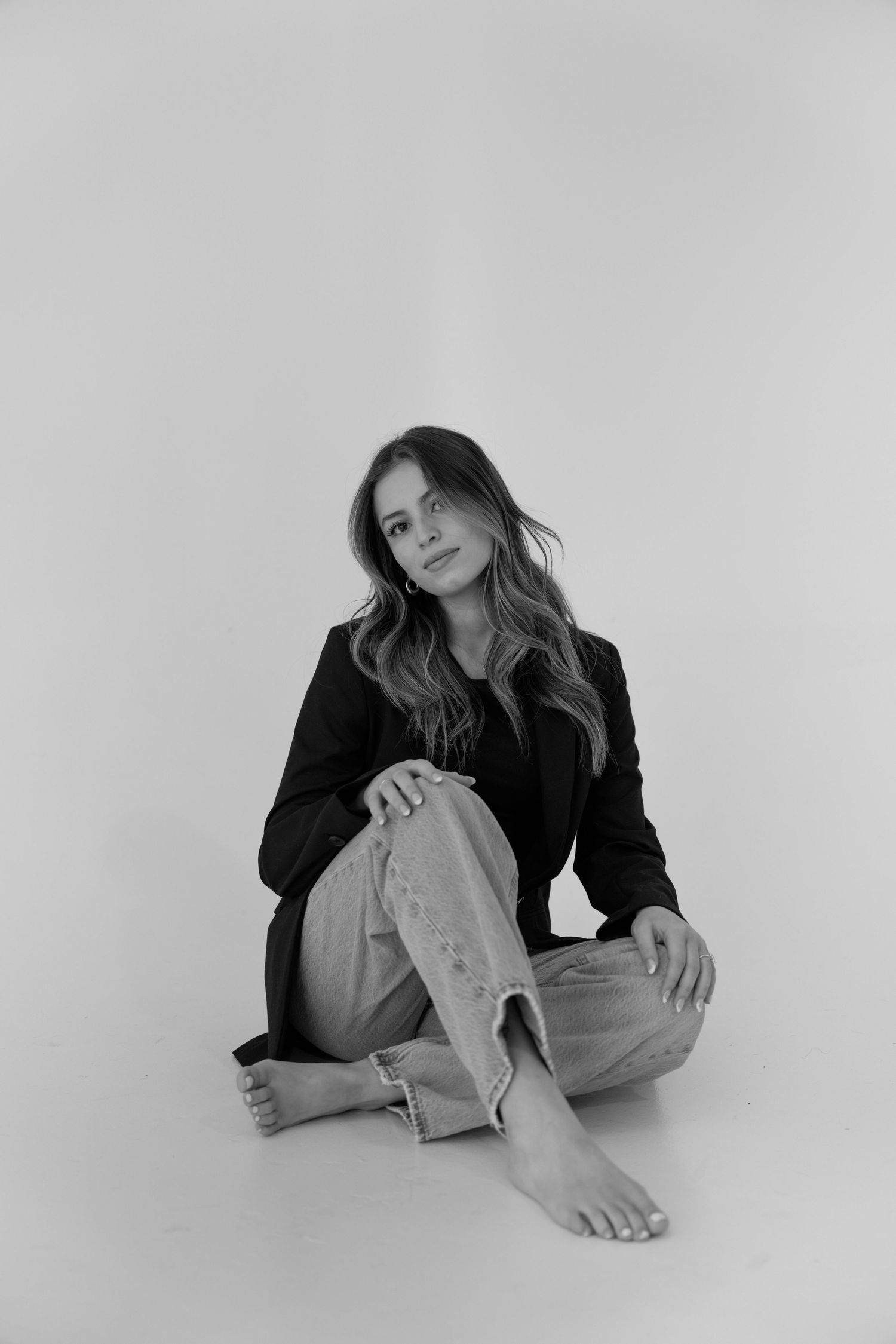 Artistic black and white portrait series showing relaxed poses against a plain background.