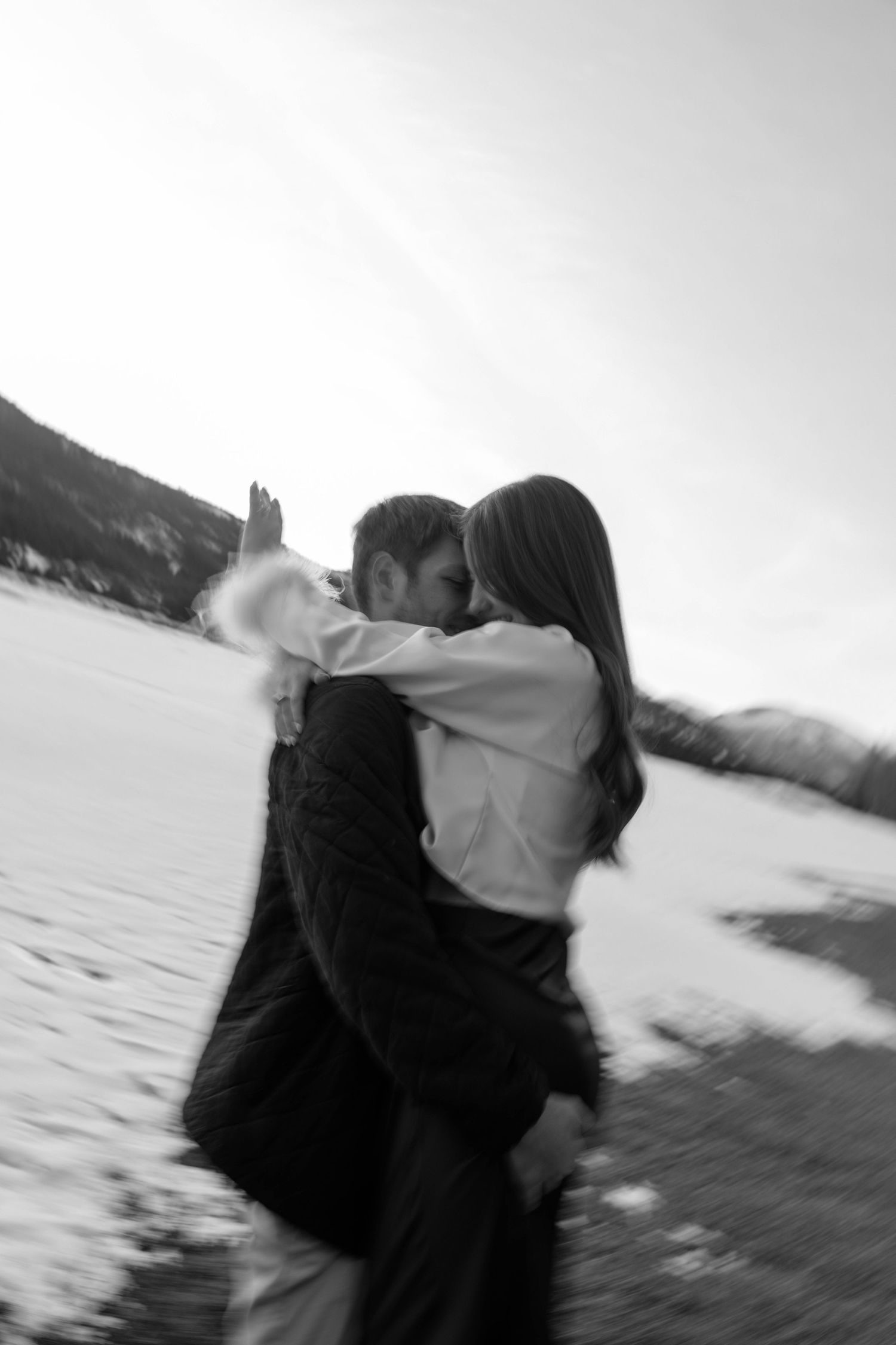 Artistic blurred motion shots of a couple dancing by a winter lake.