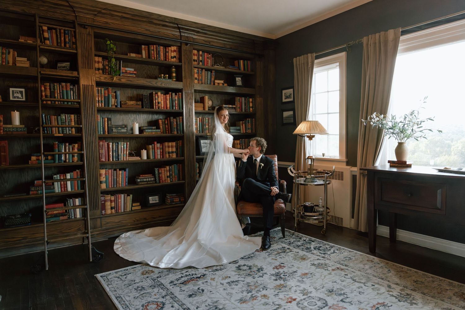 Elegant wedding photography session in a traditional library setting with leather furniture.