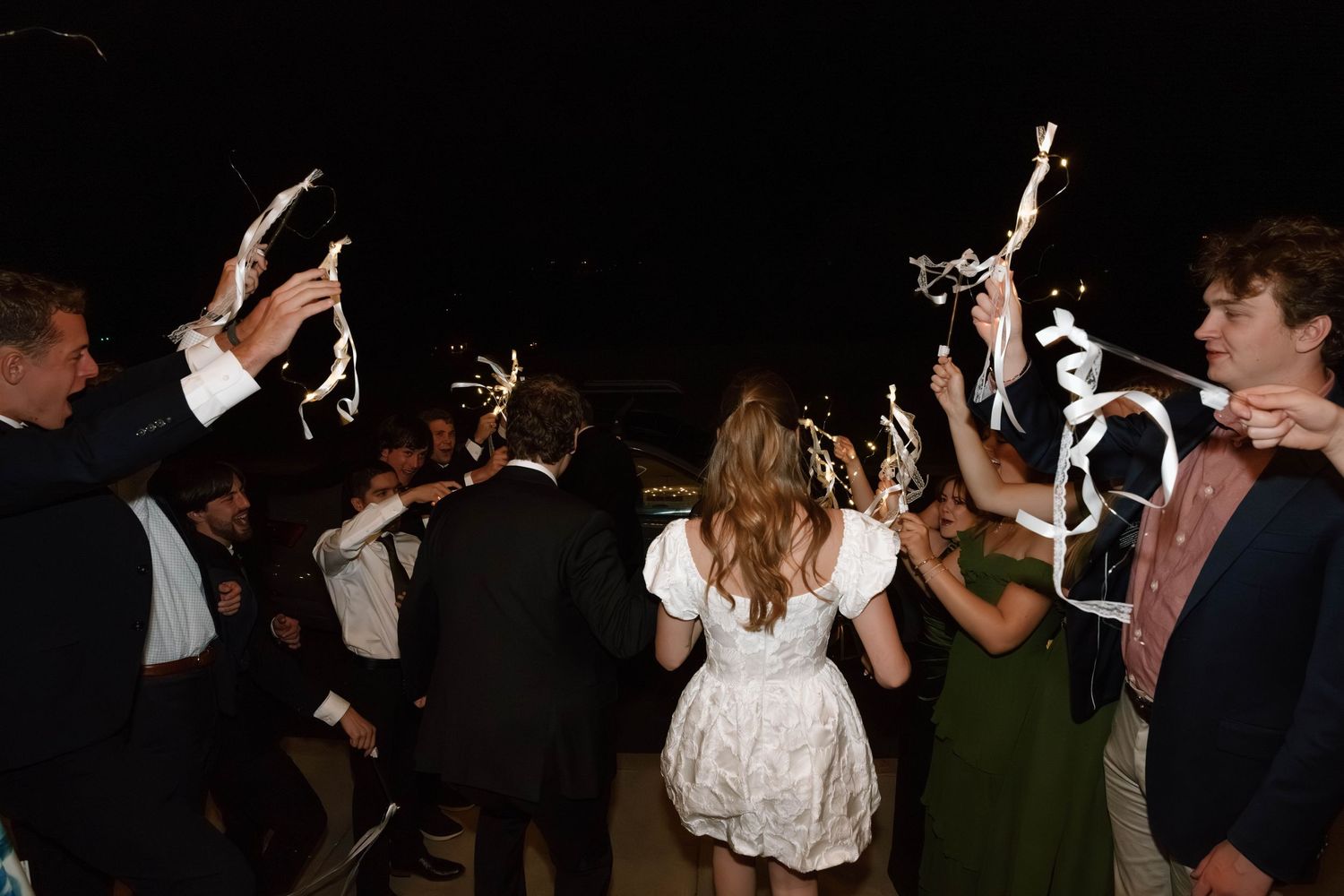 Dark silhouettes of wedding guests dancing at a reception party.
