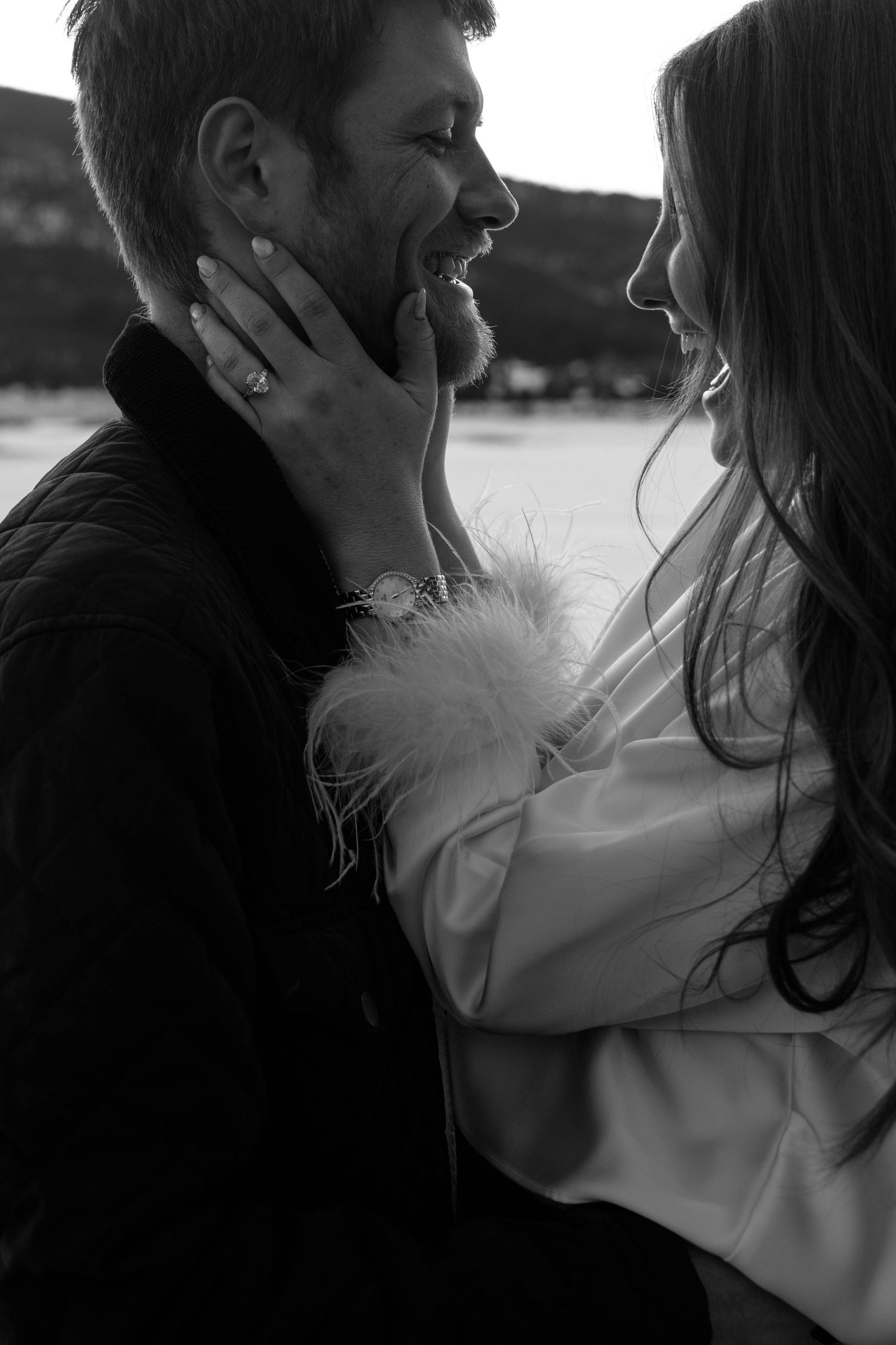 Intimate black and white portrait of a couple embracing outdoors.