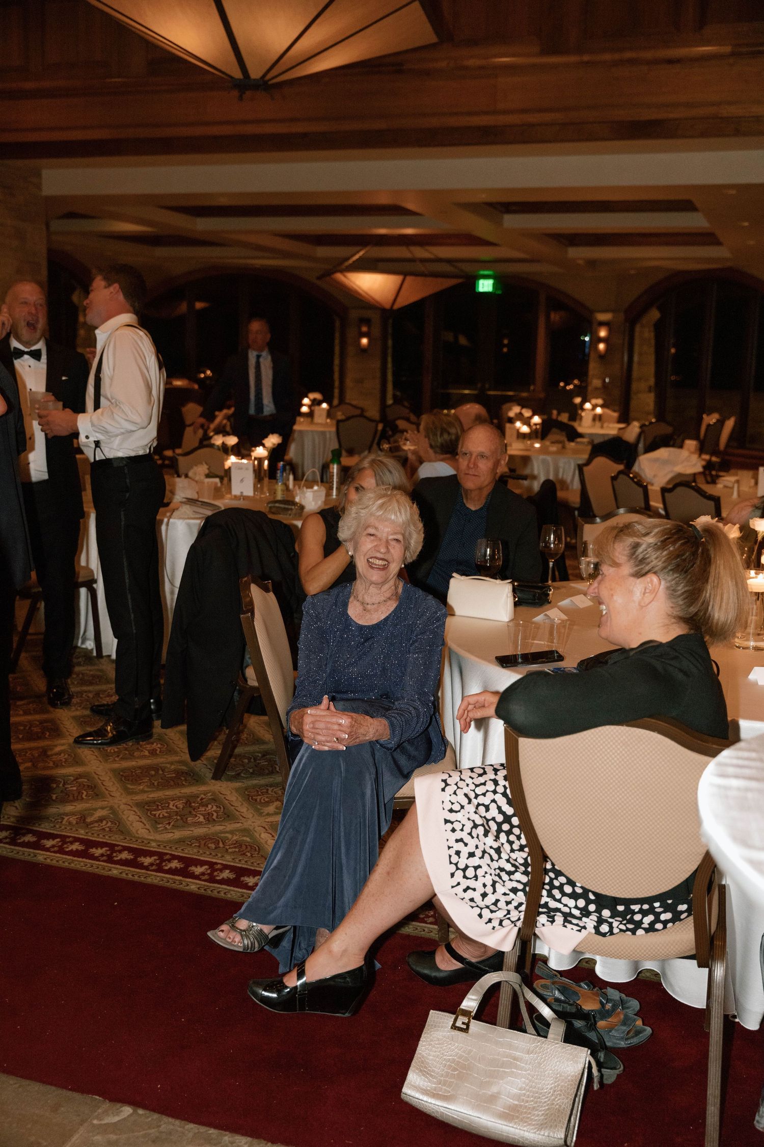 Wedding guests seated at tables during reception in an elegant banquet hall.