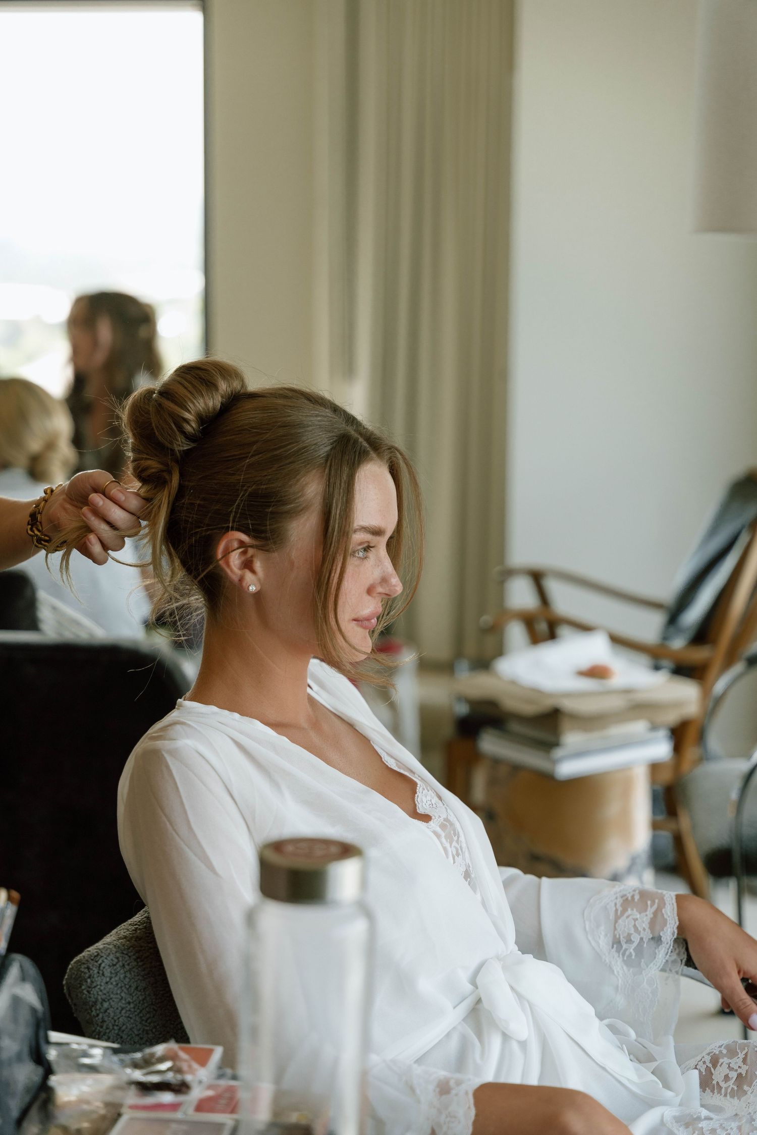A serene getting-ready moment in a sunlit room with professional styling equipment.