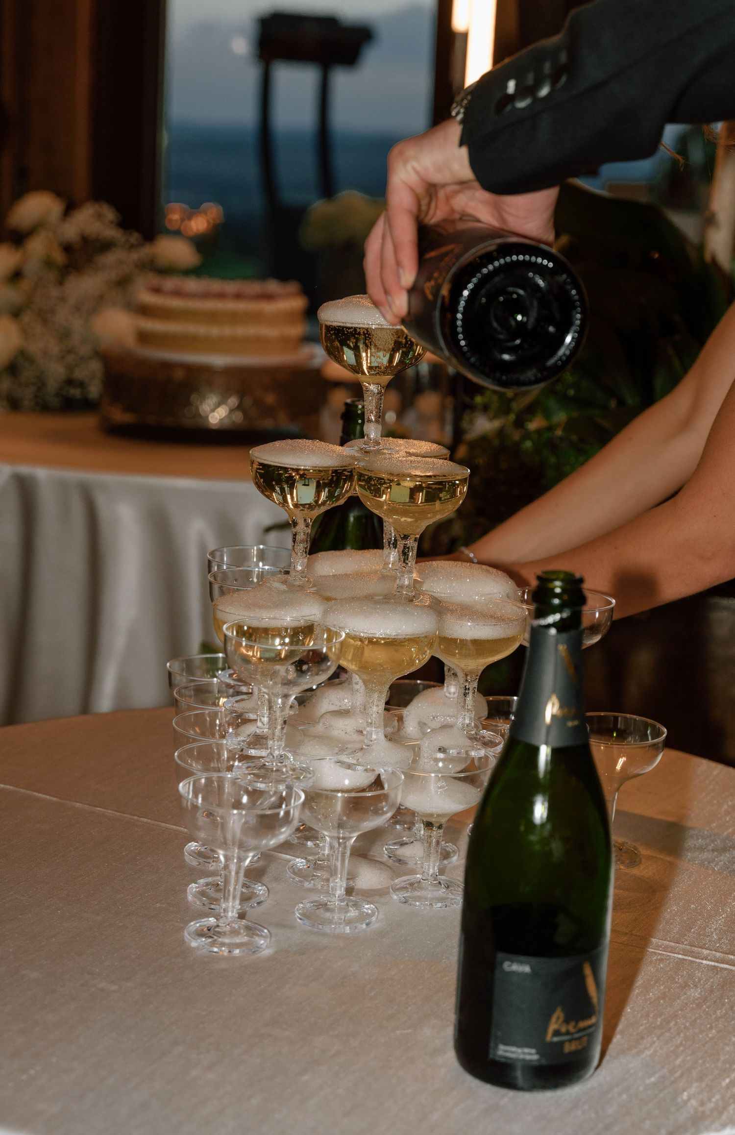 Champagne being poured into coupe glasses at an elegant event reception.