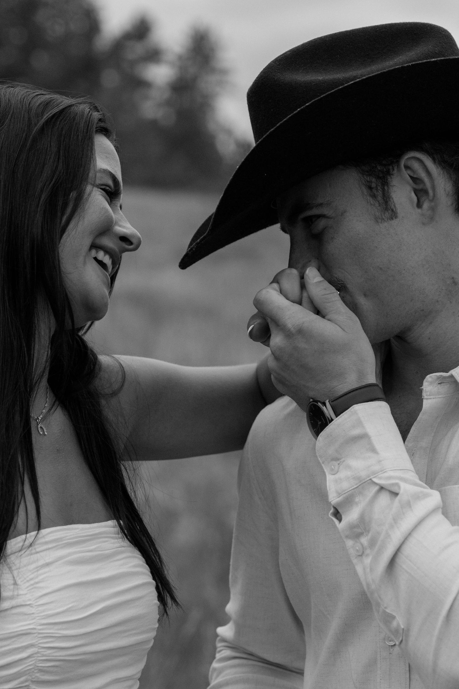 A romantic black and white portrait showing an intimate gesture in western style.