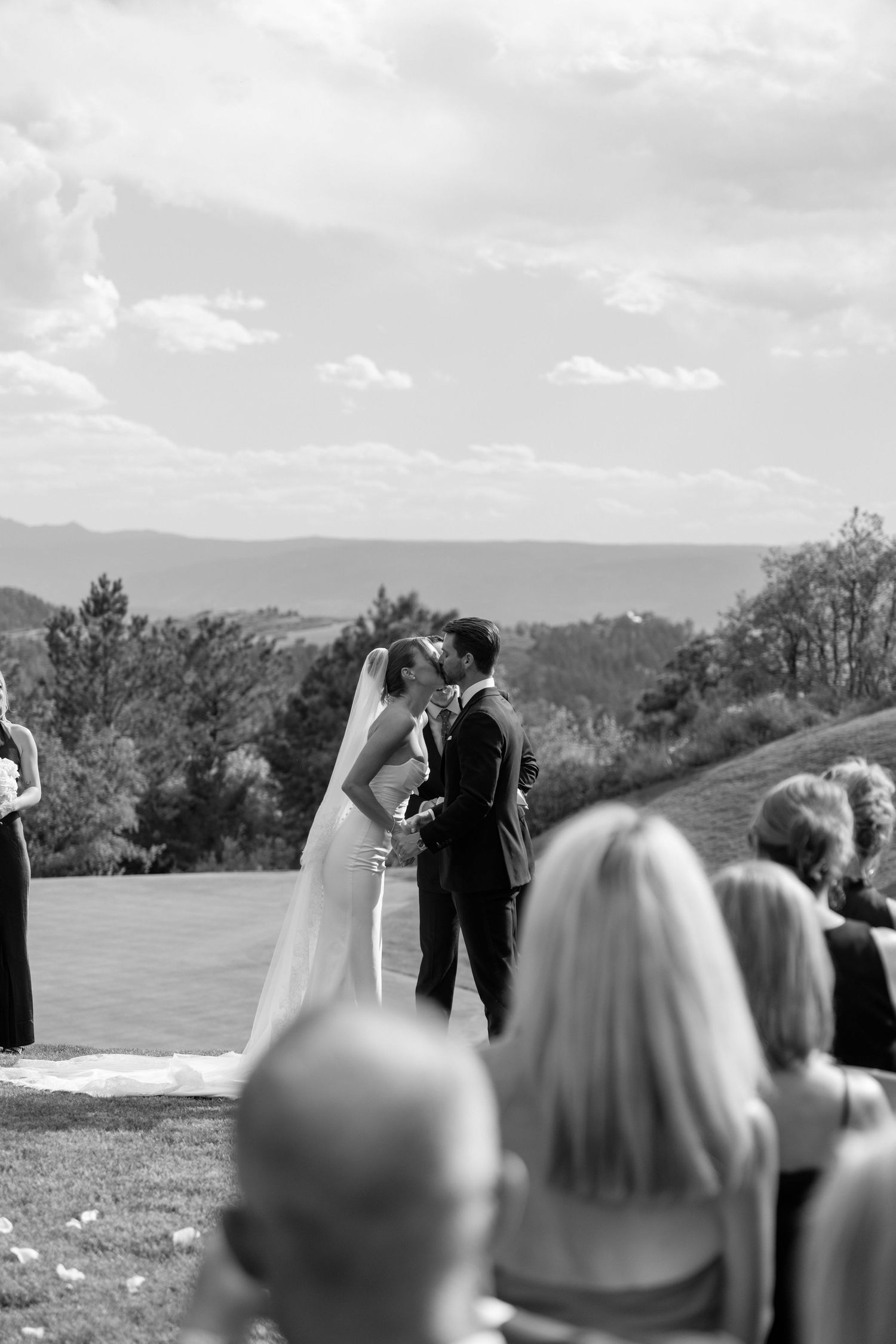 Black and white wedding ceremony photo with mountain vista backdrop.
