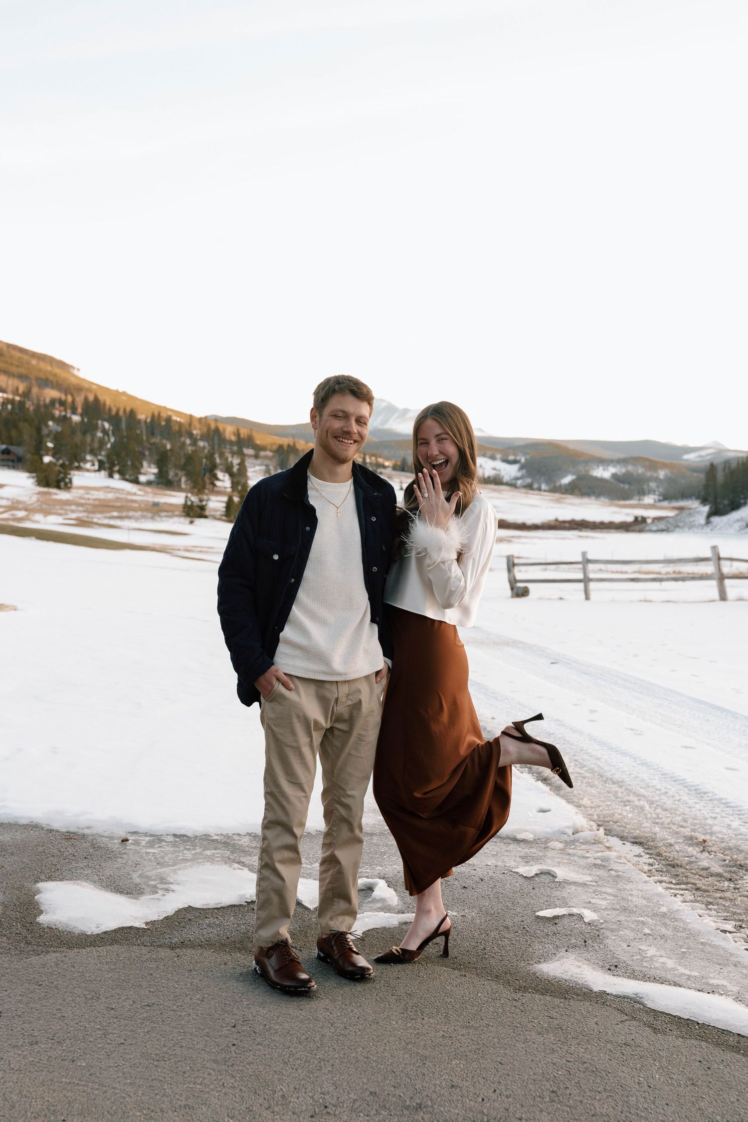 Couple walking playfully together on a snowy mountain path.
