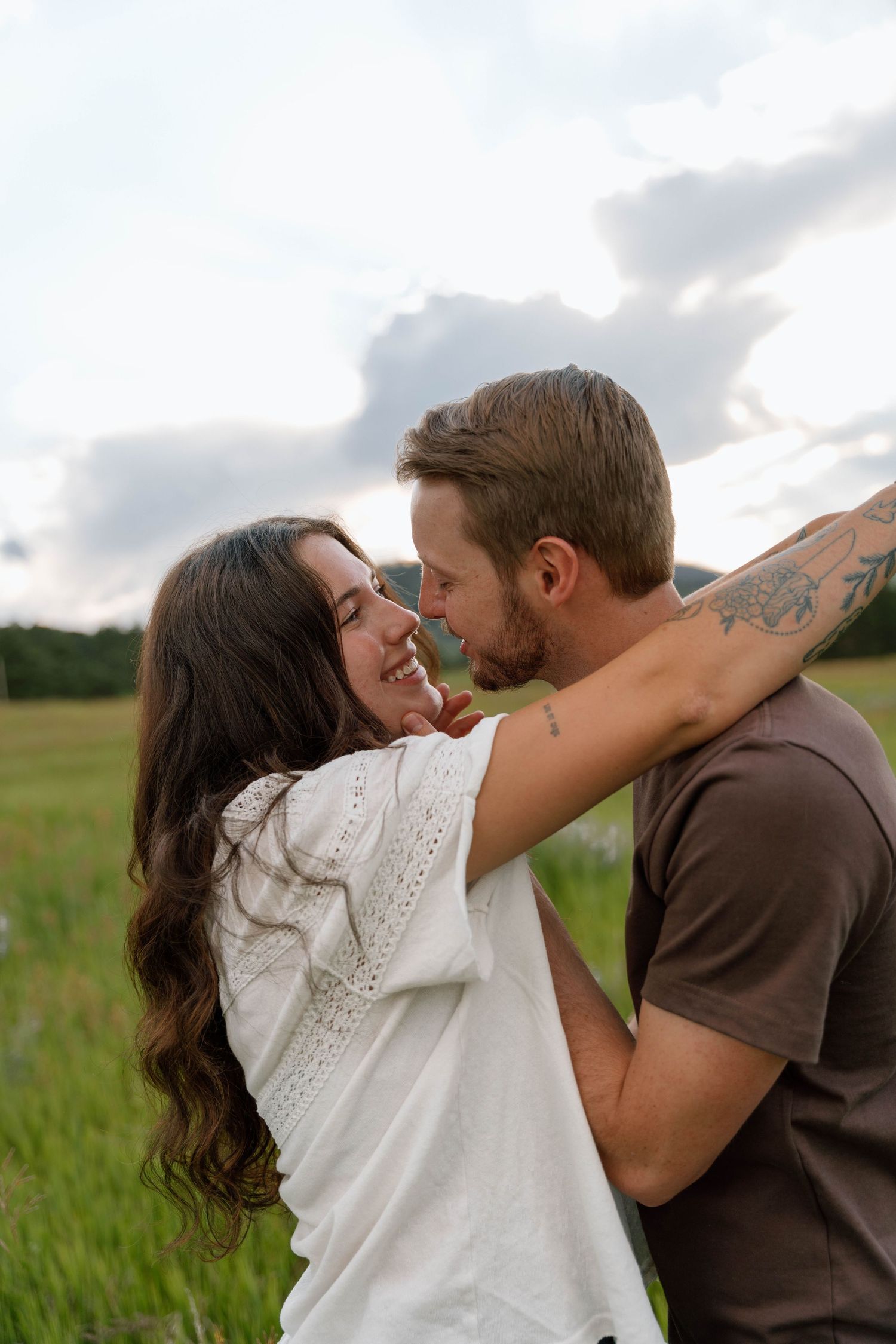 Romantic couple embracing in a wildflower field during golden hour.