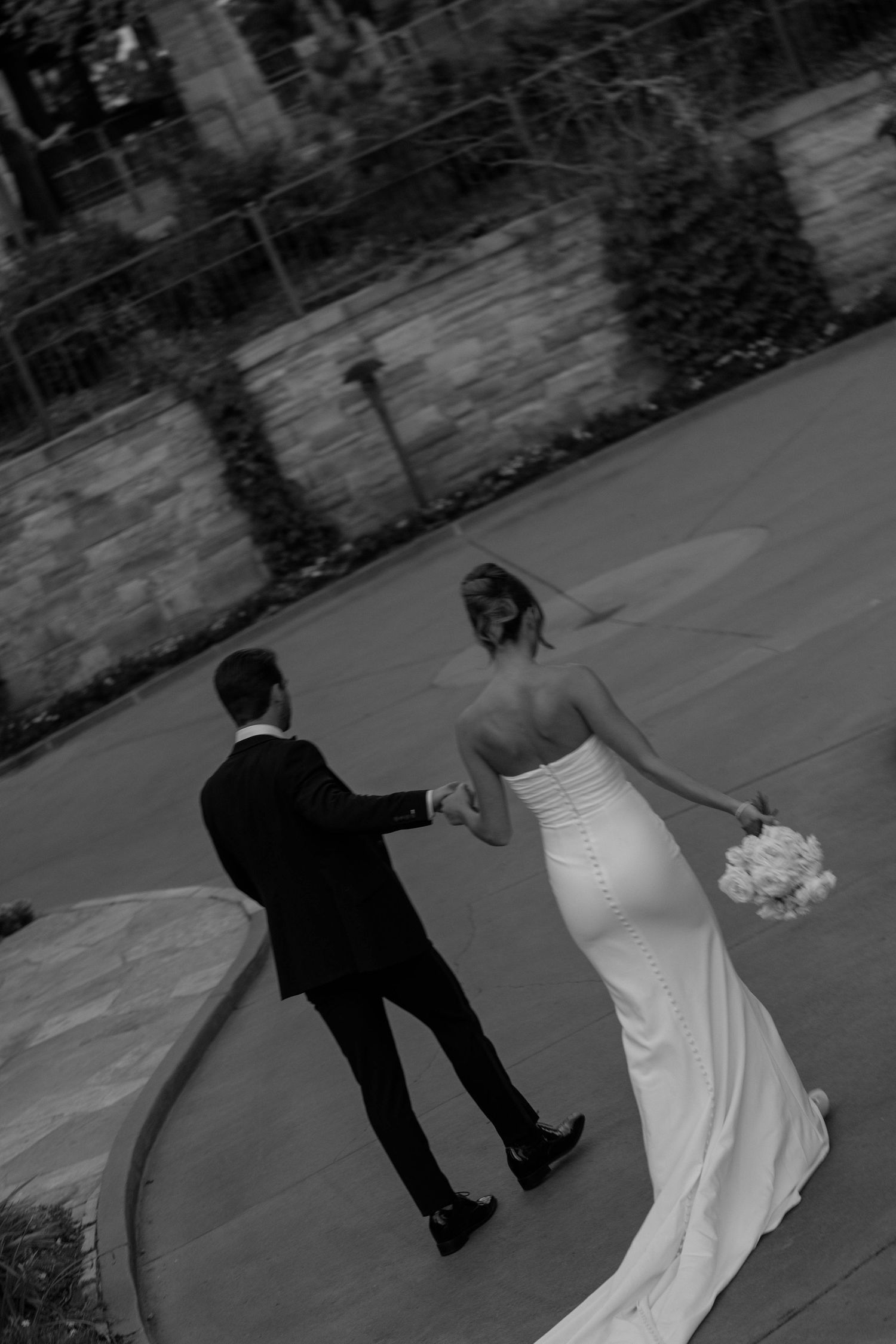 A black and white wedding photo showing a couple dancing on an outdoor patio.