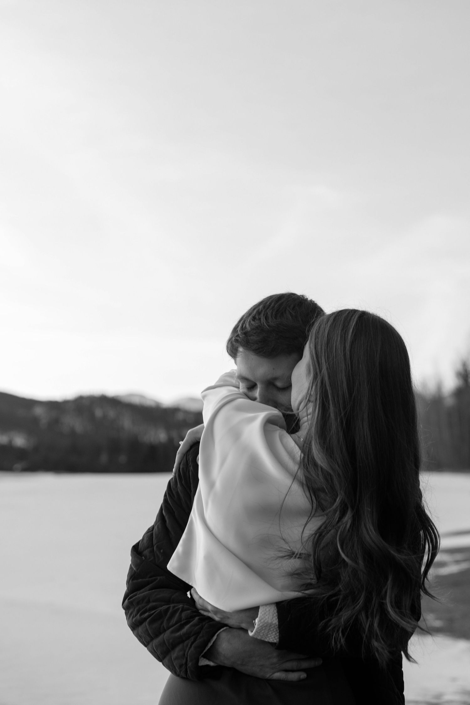 Black and white romantic portraits captured against a serene winter landscape.