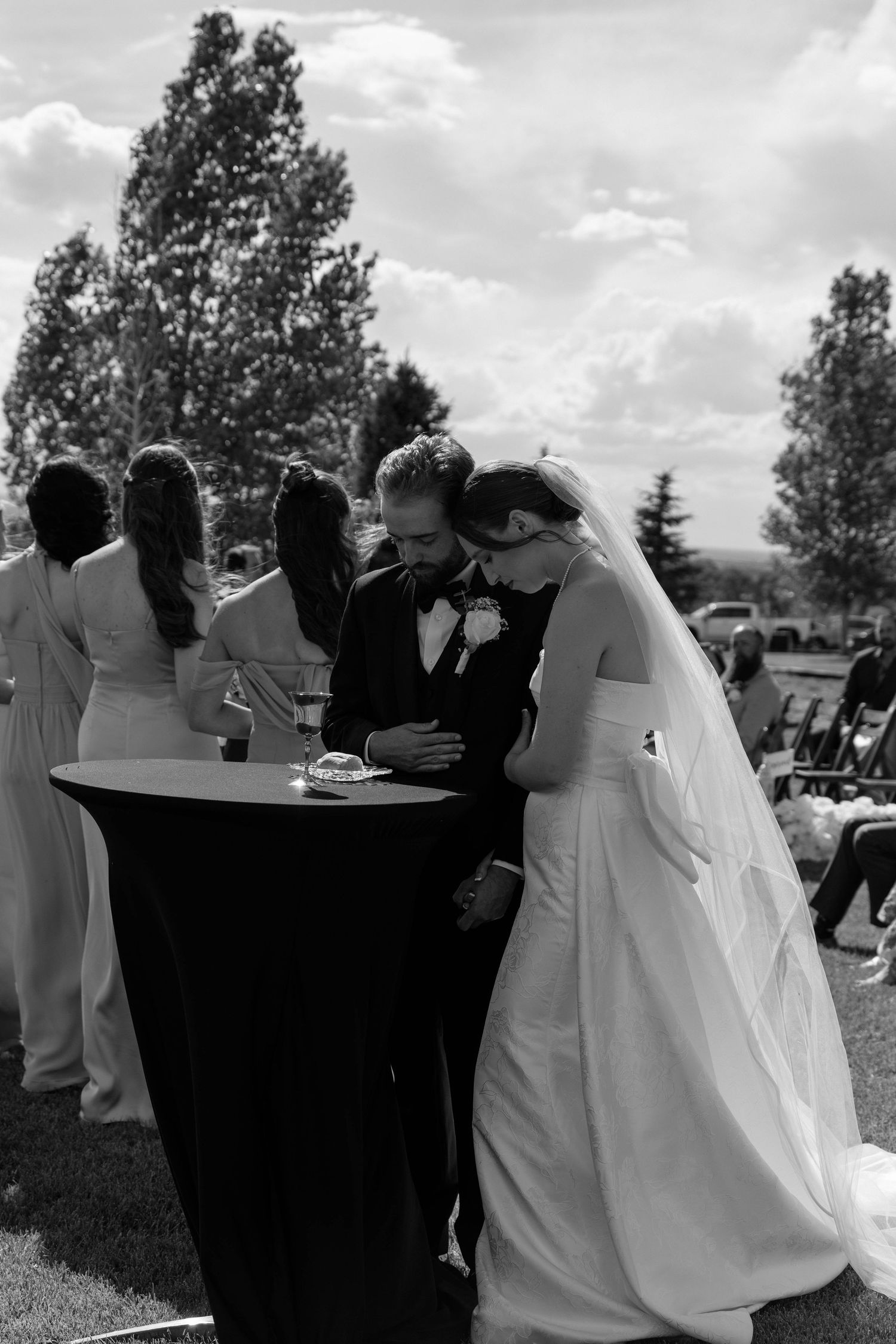 Black and white photo of bride and groom sharing intimate moment at cocktail hour outdoor reception.