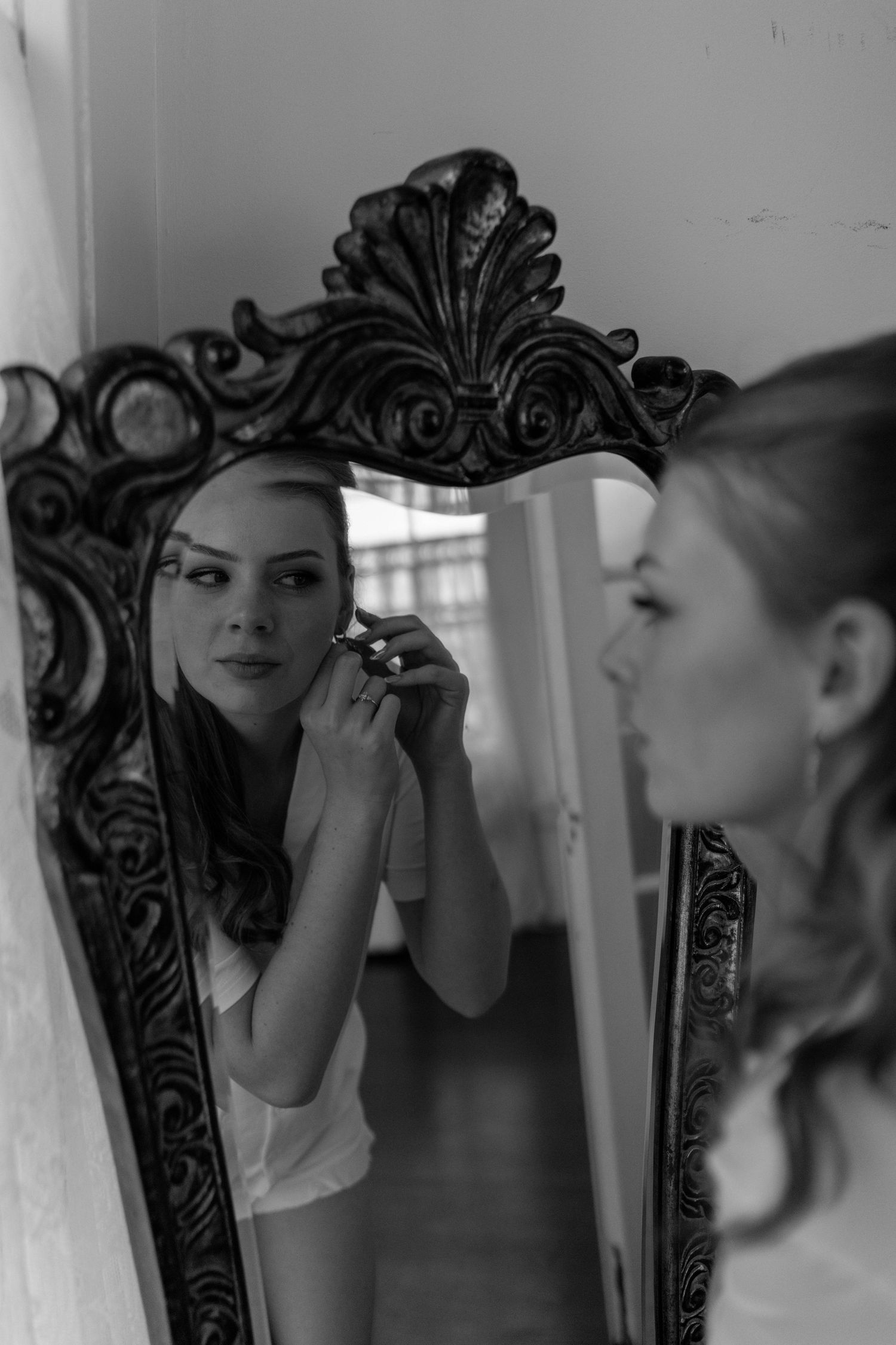 Ornate vintage mirror reflection in dramatic black and white photography.
