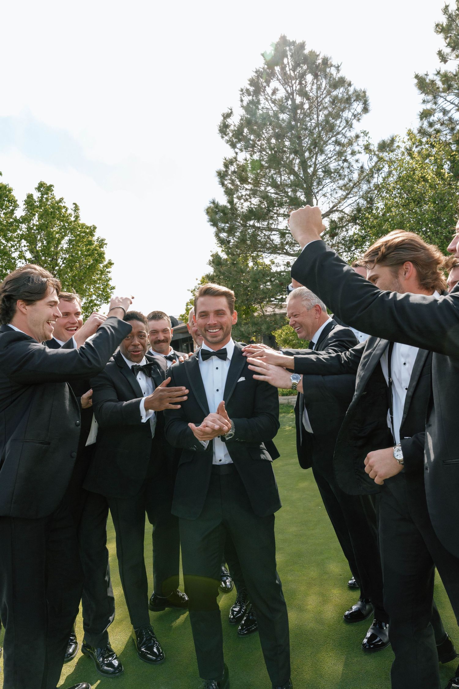 A celebratory moment captured with a group in formal attire on a lawn.