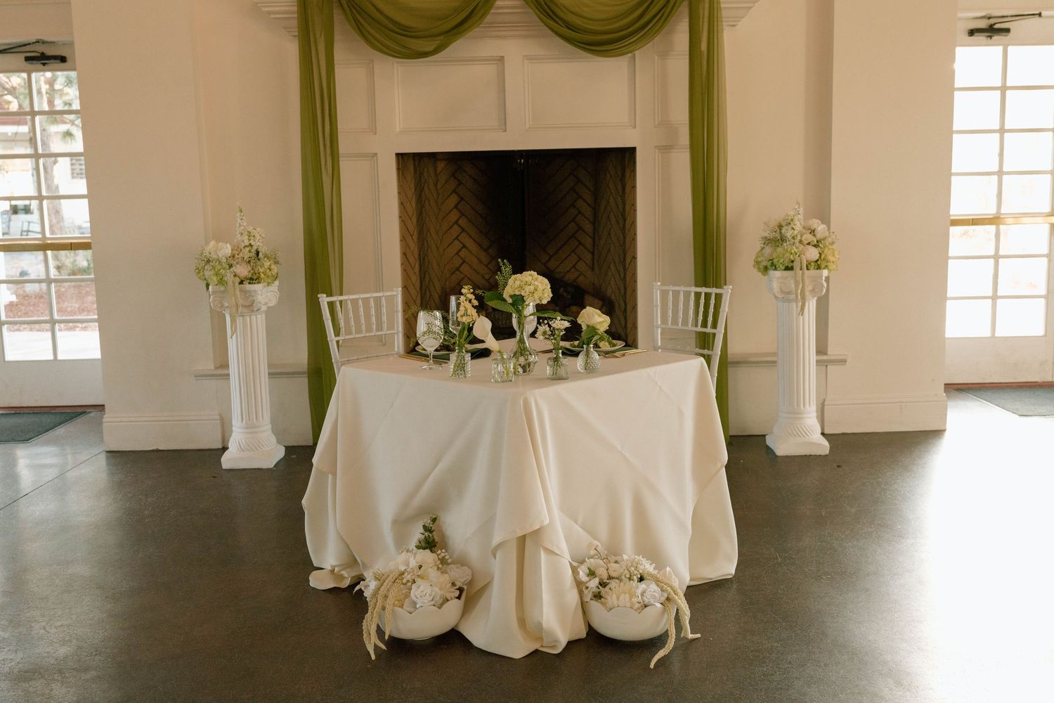 Wedding reception venue with white tablecloths and elegant decor in a spacious room.