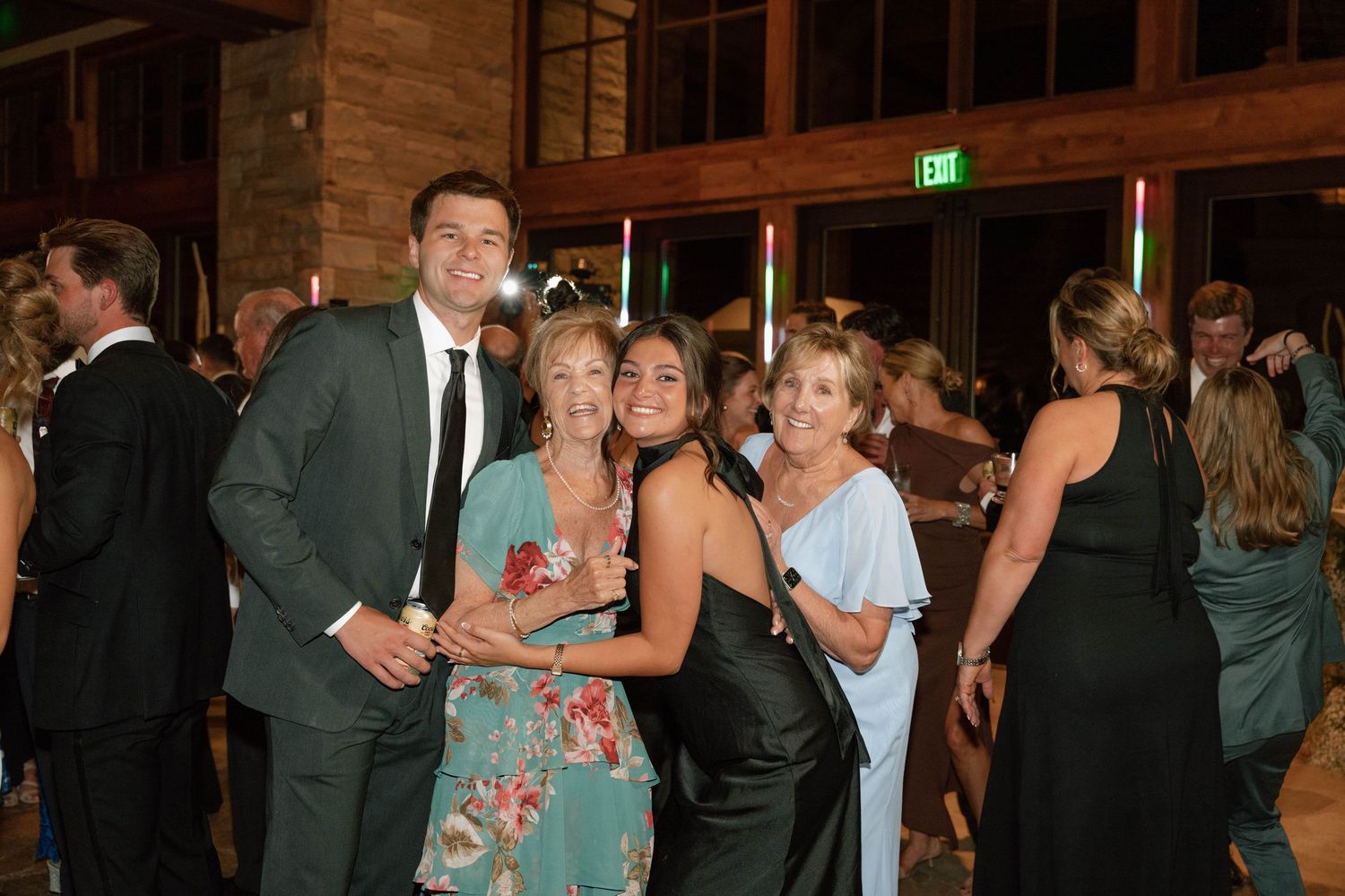 Wedding guests enjoying themselves on a lively dance floor at an indoor venue.