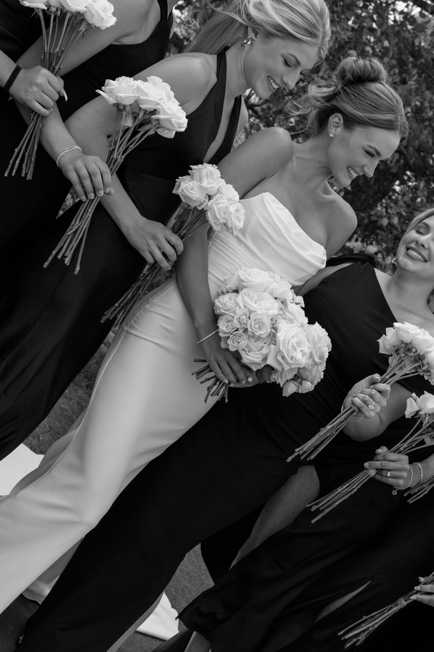 Black and white photo of a wedding party holding bouquets of white flowers.